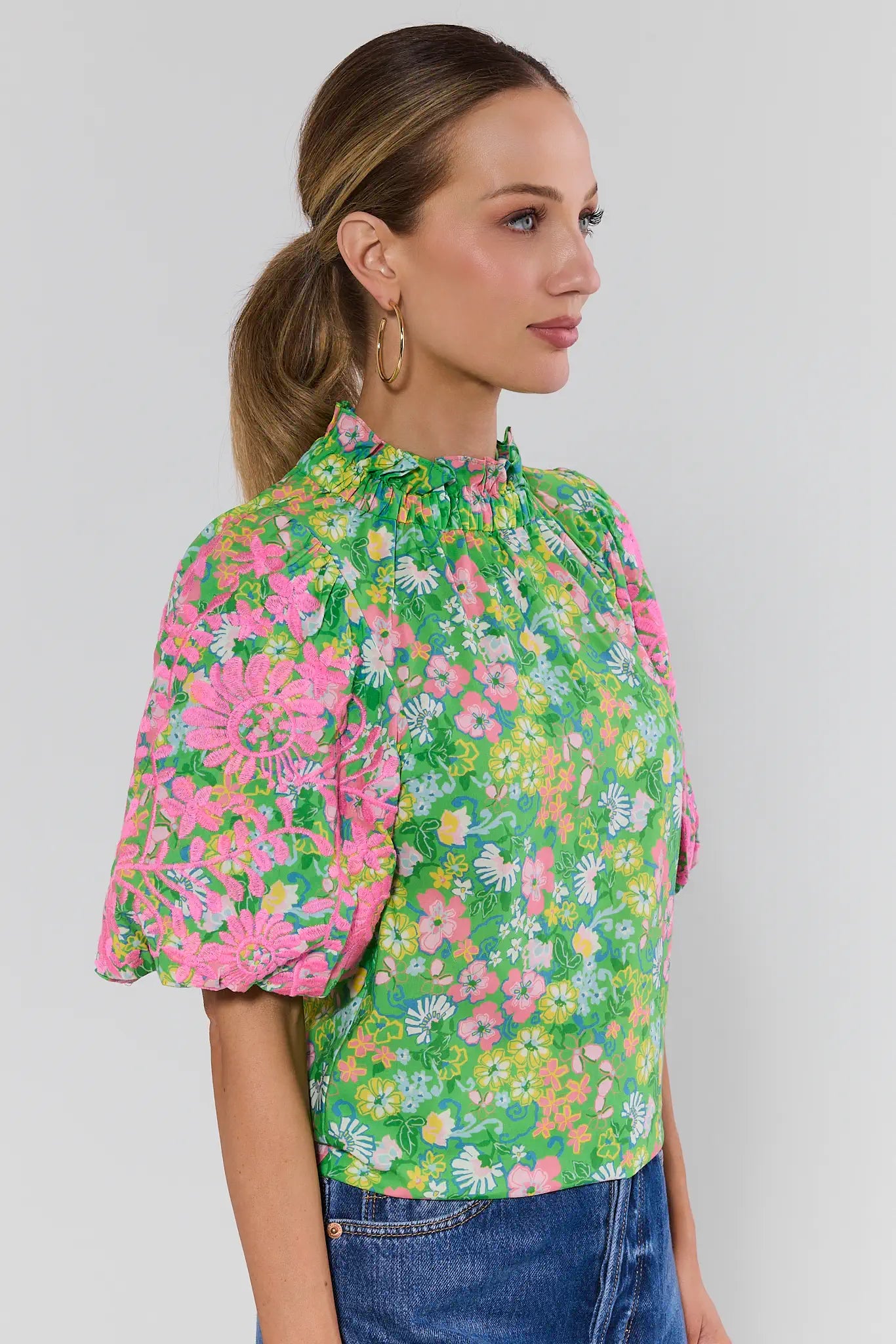 Woman wearing a colorful floral blouse against a background