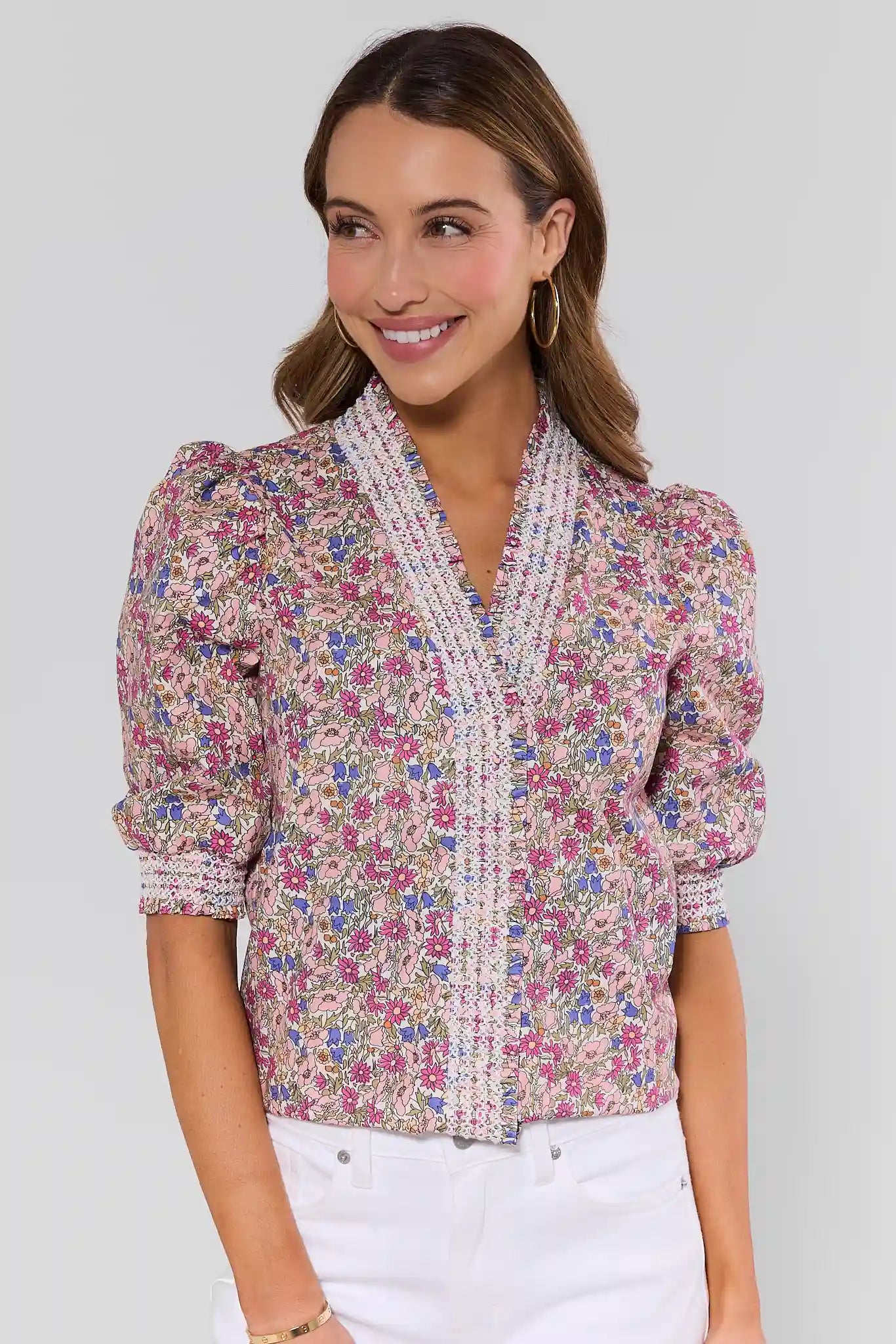 Woman wearing a floral blouse with a white plain background