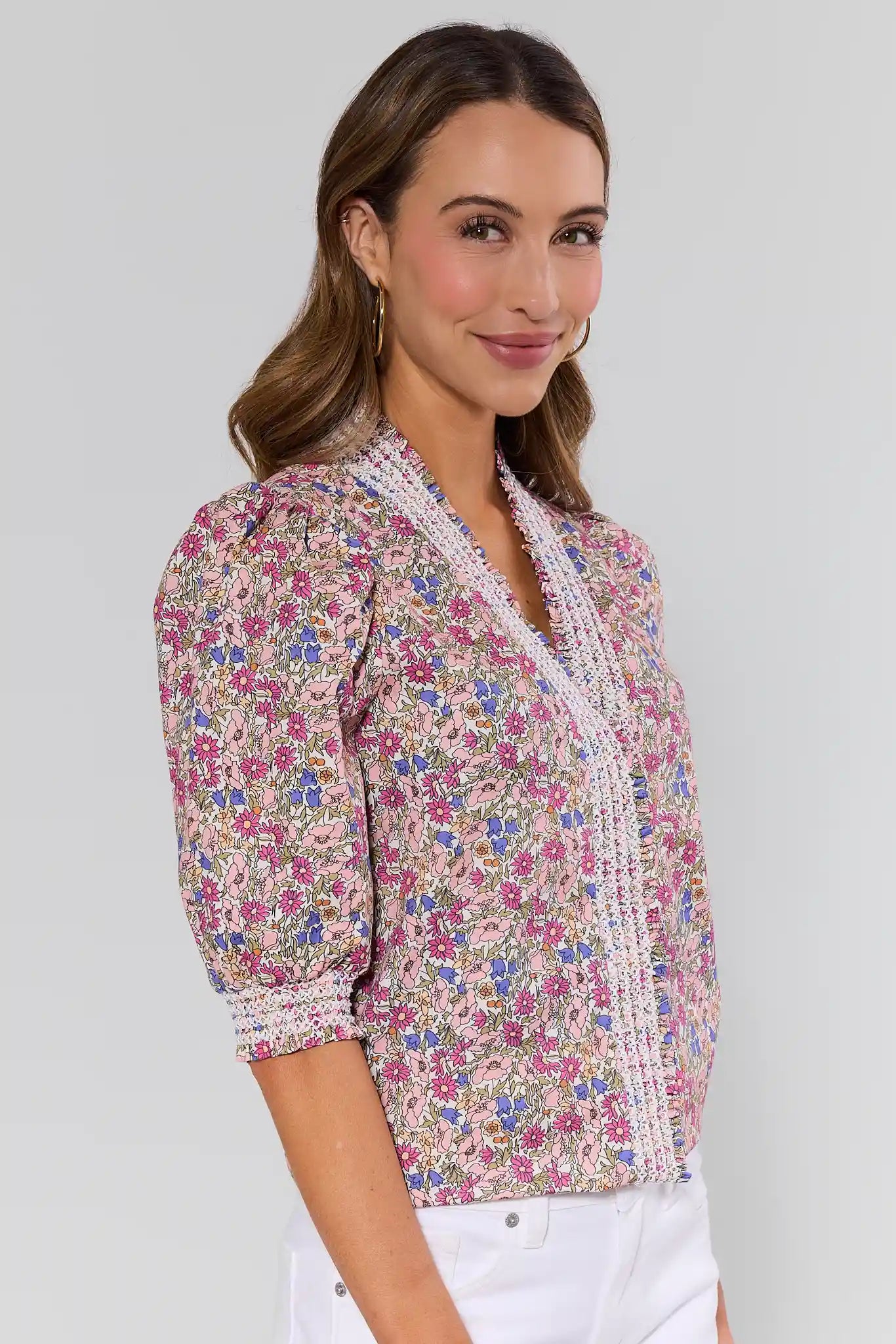 side shot Woman wearing a floral blouse with a plain background