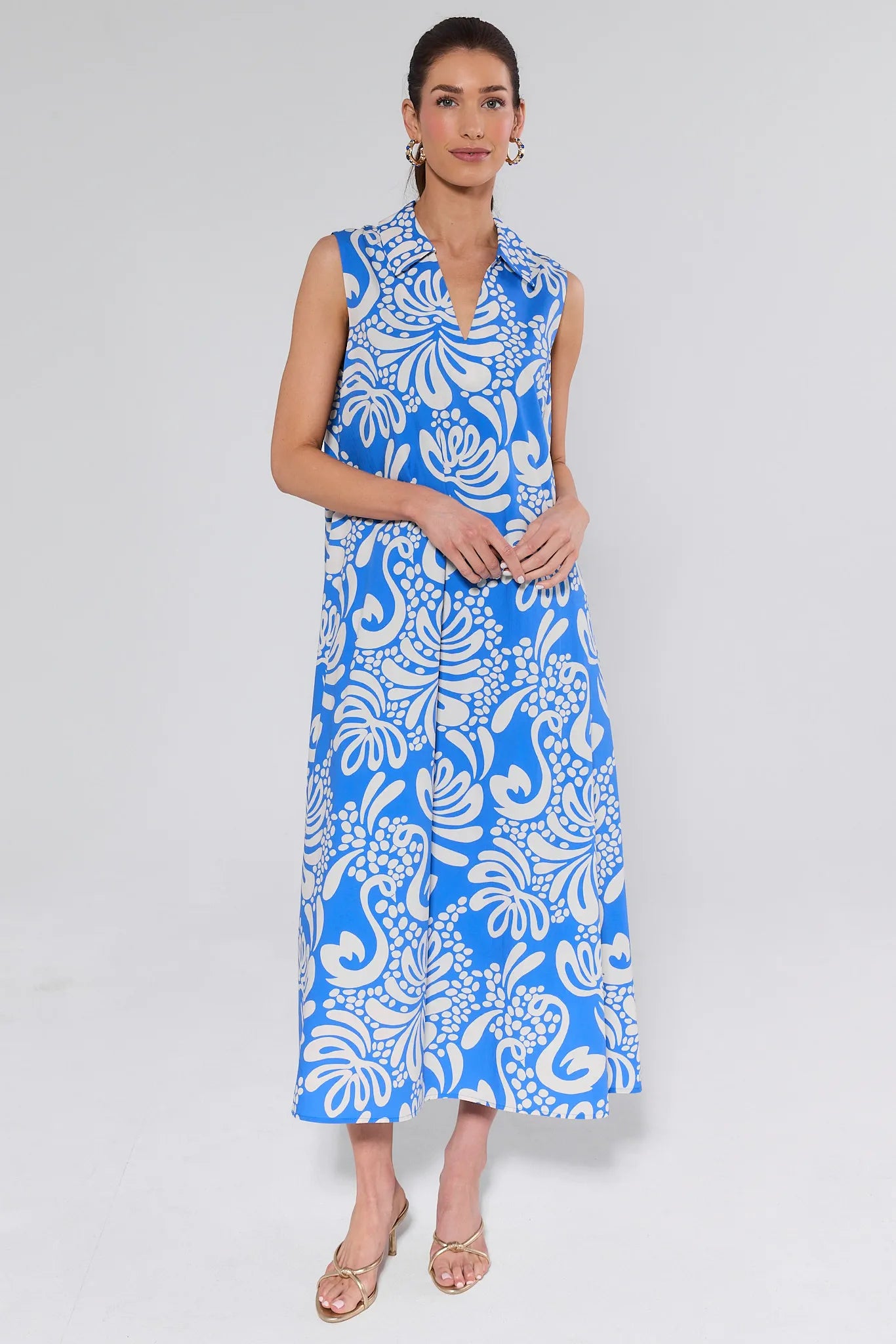 Woman wearing a blue and white floral dress on a gray background