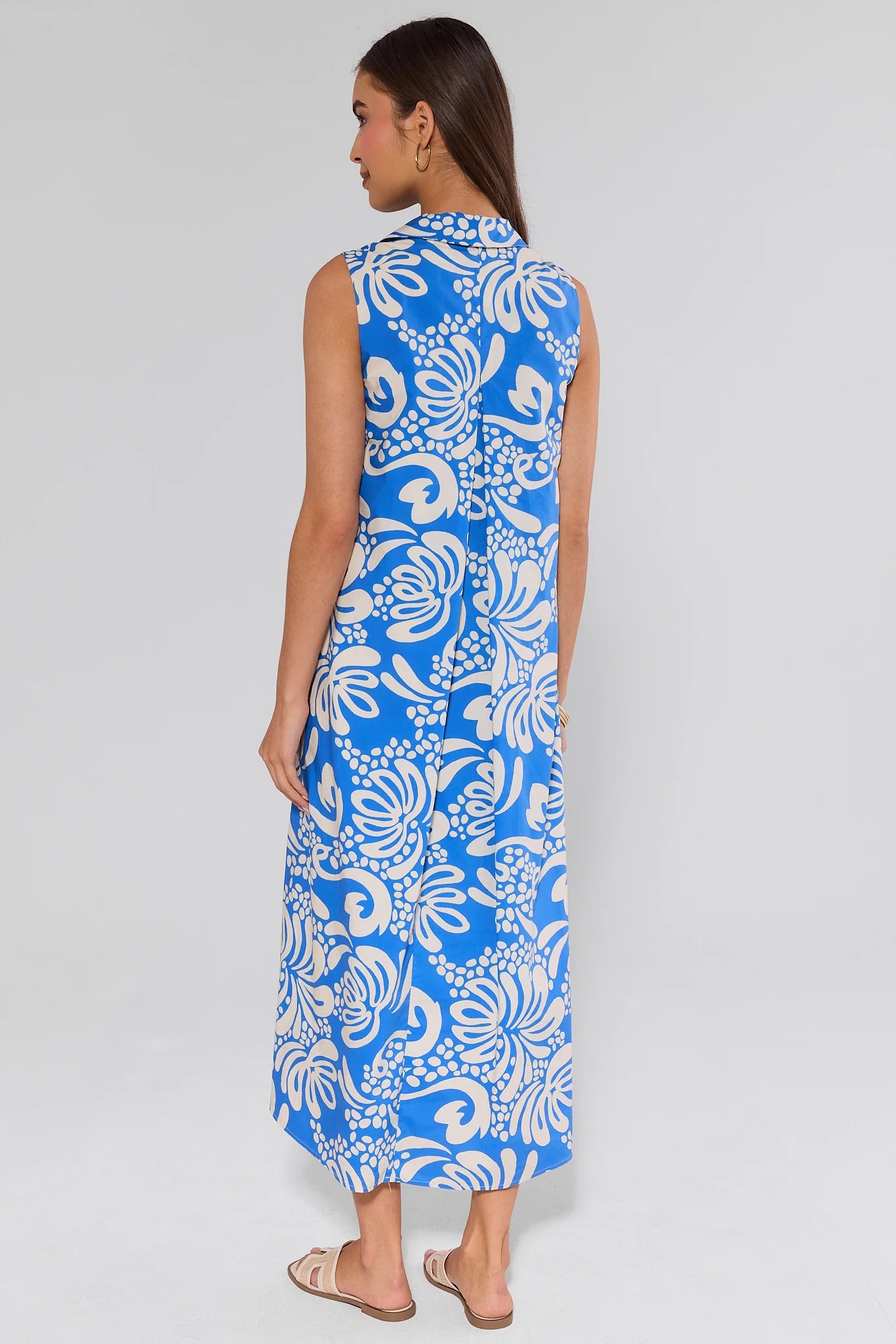 Woman wearing a blue and white floral dress on a gray background