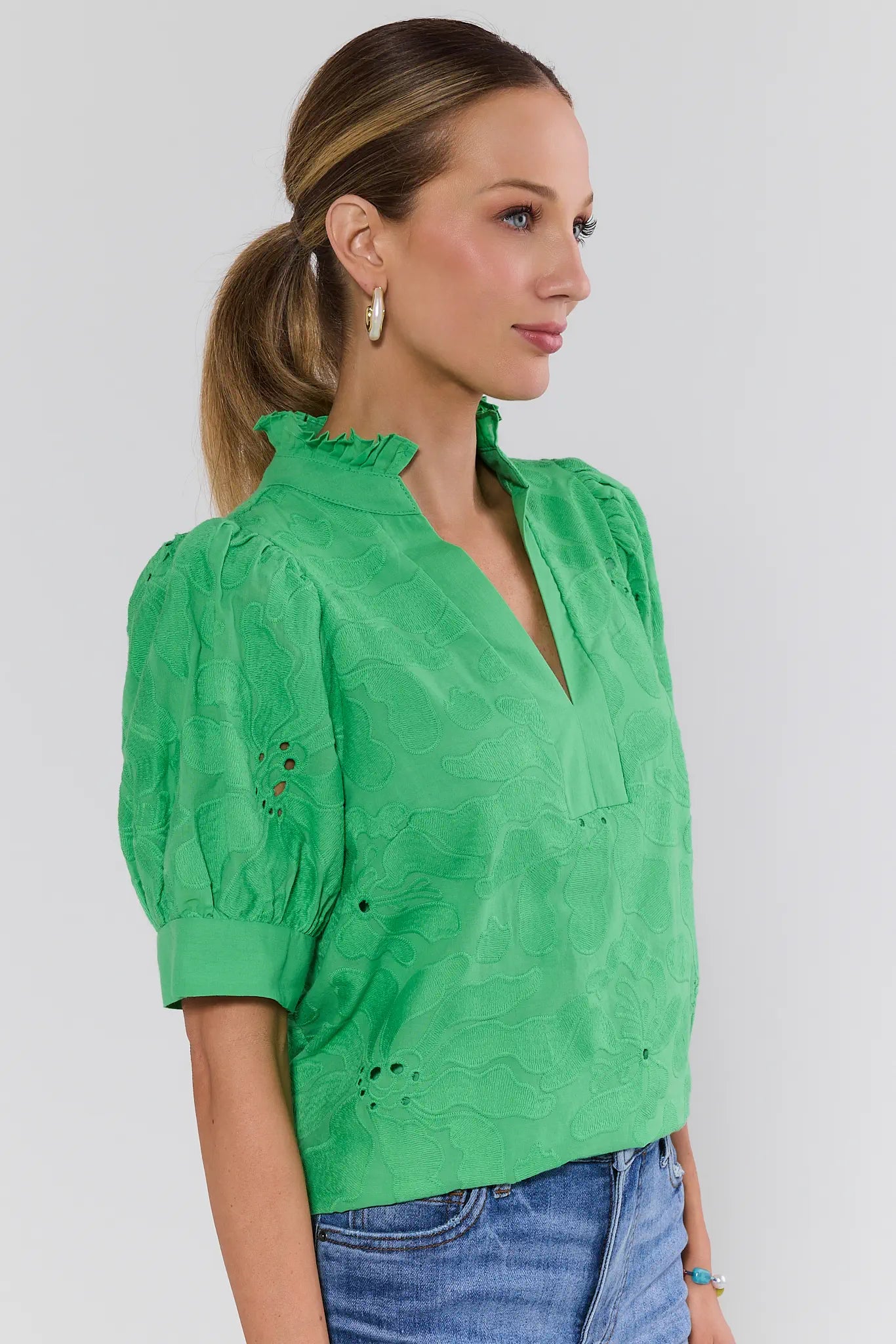 Woman wearing a green blouse with a plain background