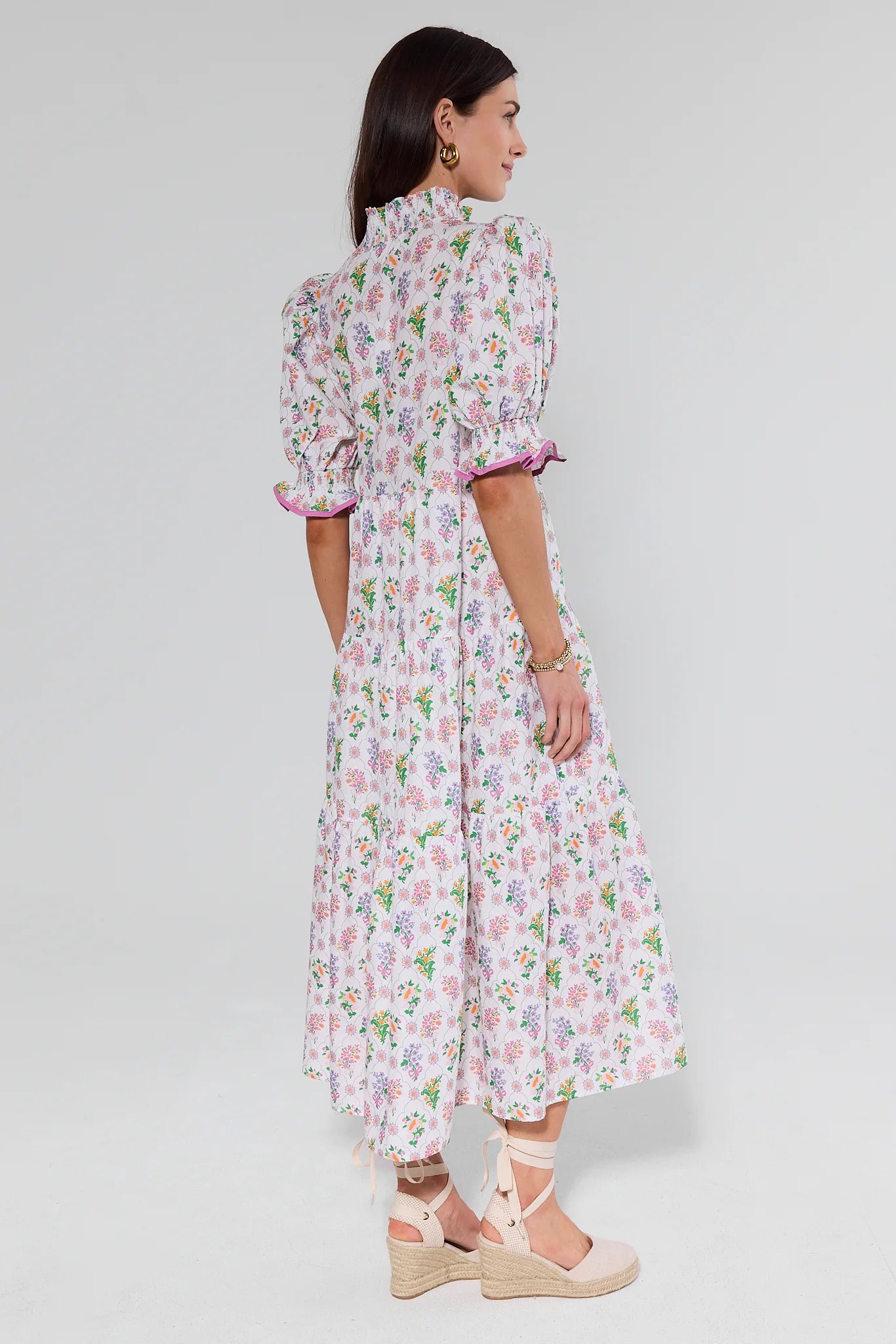 View 1: Woman wearing a floral dress on a white background