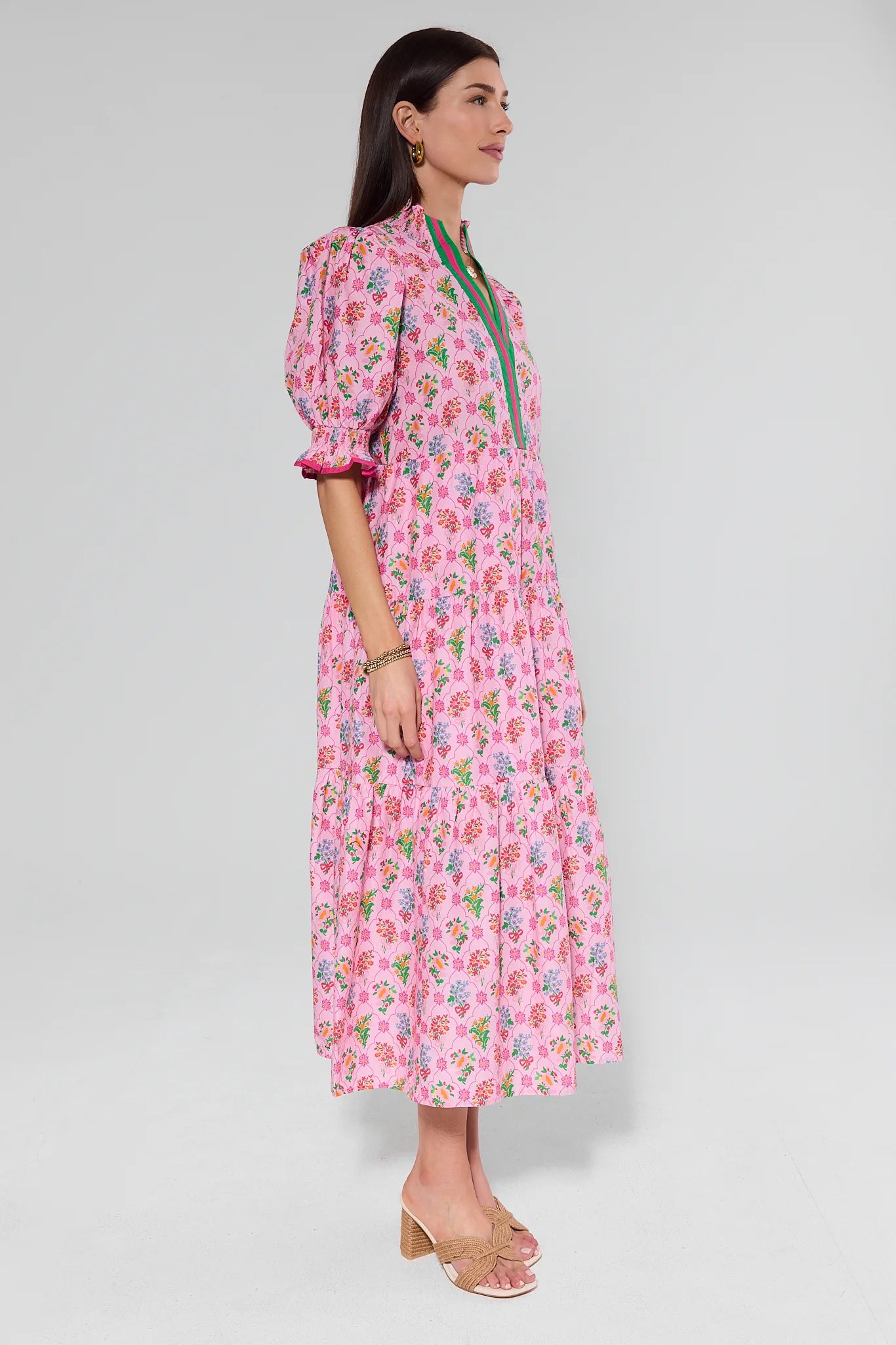 Woman wearing a pink floral dress on a gray background