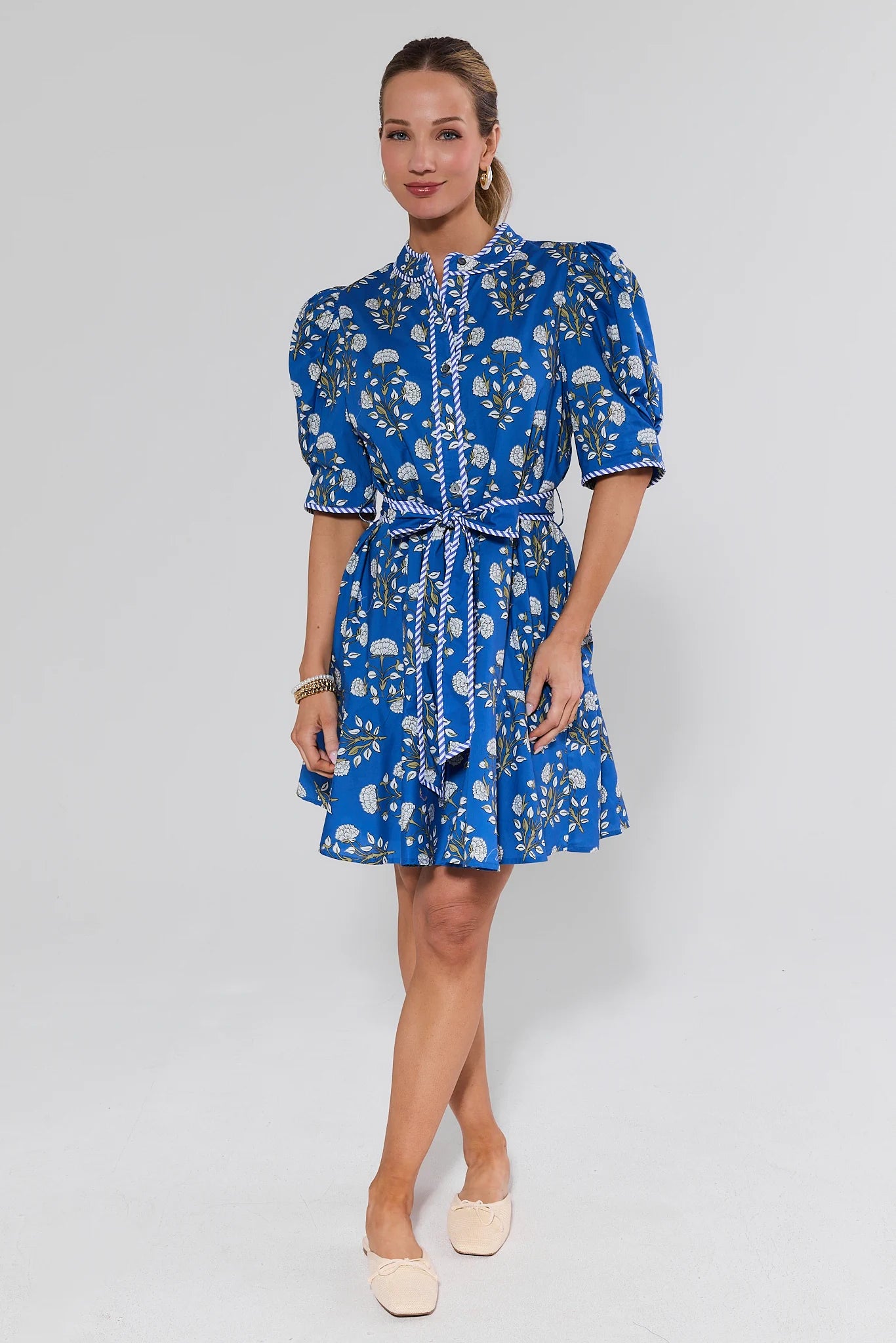 Woman wearing a blue floral dress on a white background
