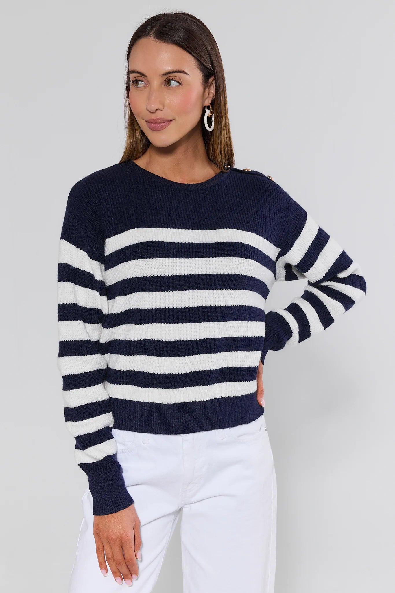 Woman wearing a navy and white striped sweater against a plain background