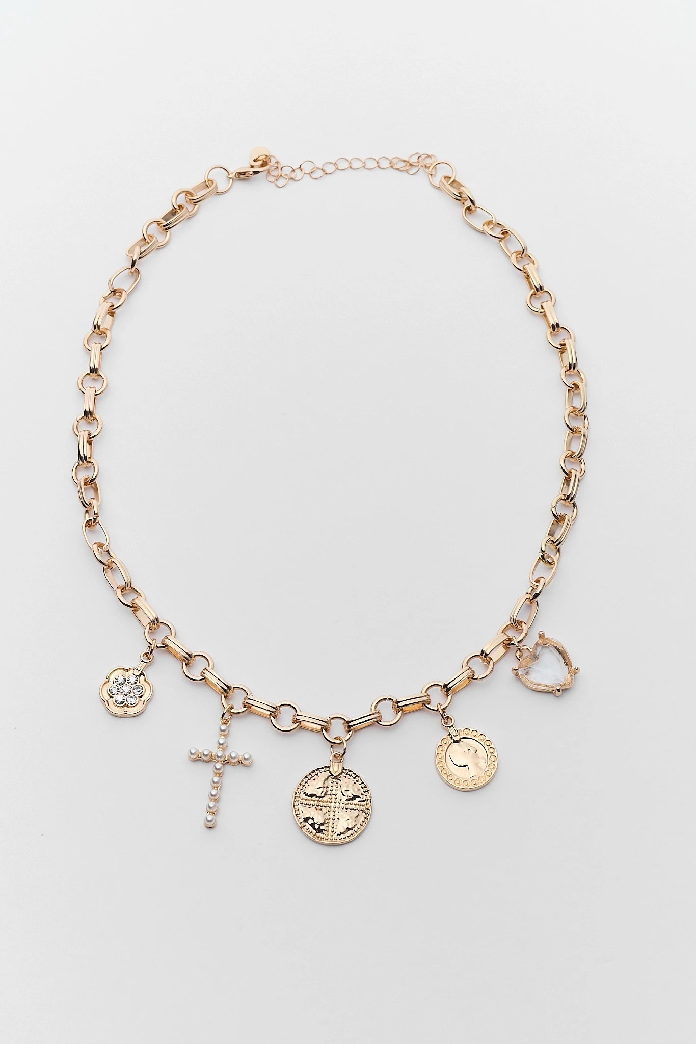 Gold necklace with various charms on a light gray background