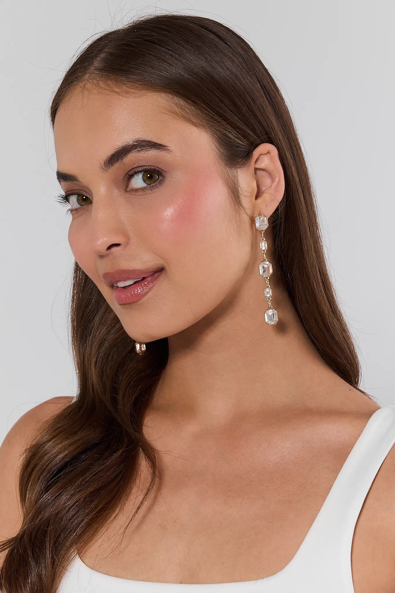 woman wearing Diana Gold Rhinestone Drop Earrings on white background