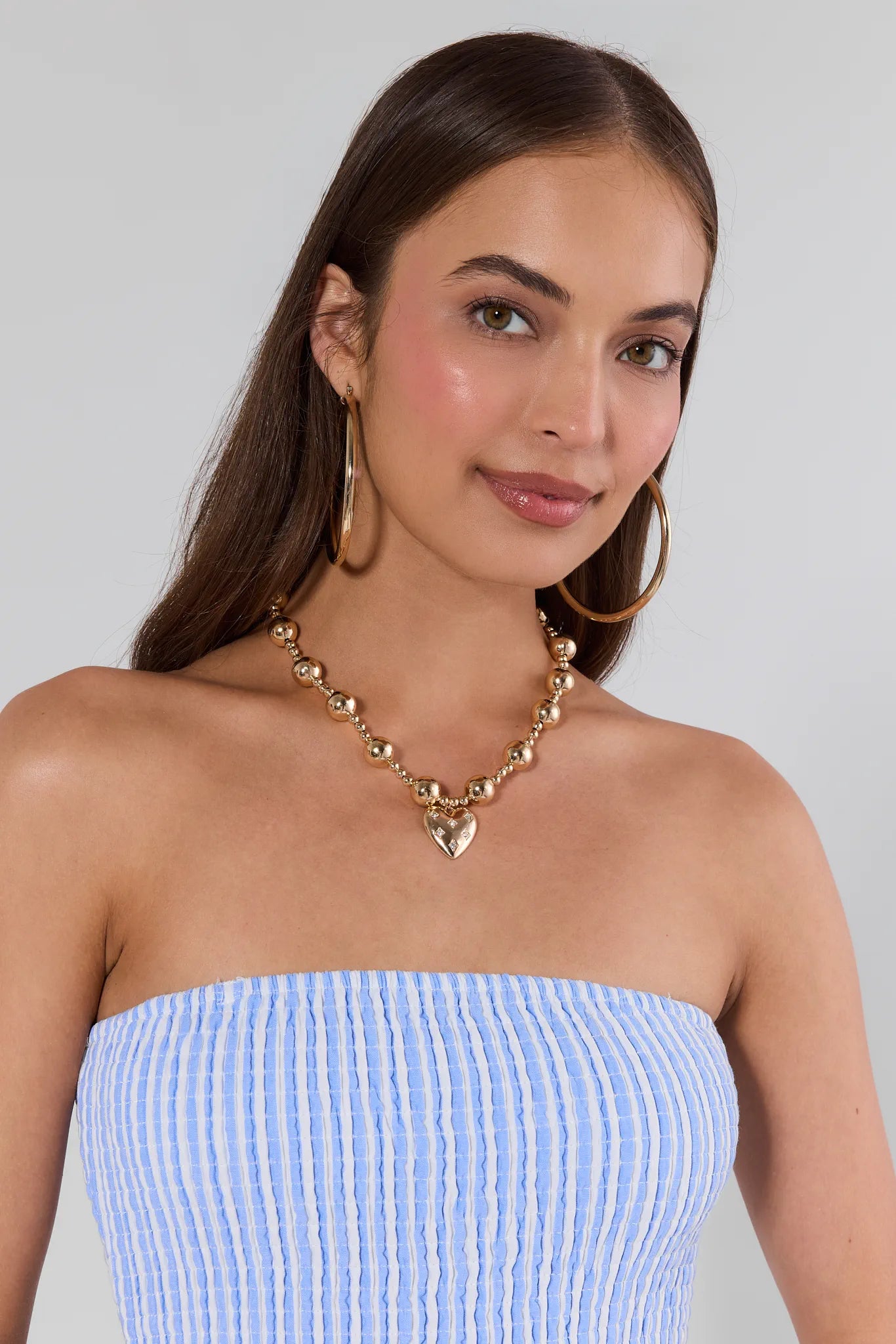 woman wearing Madeline Gold Beaded Heart Necklace on white background