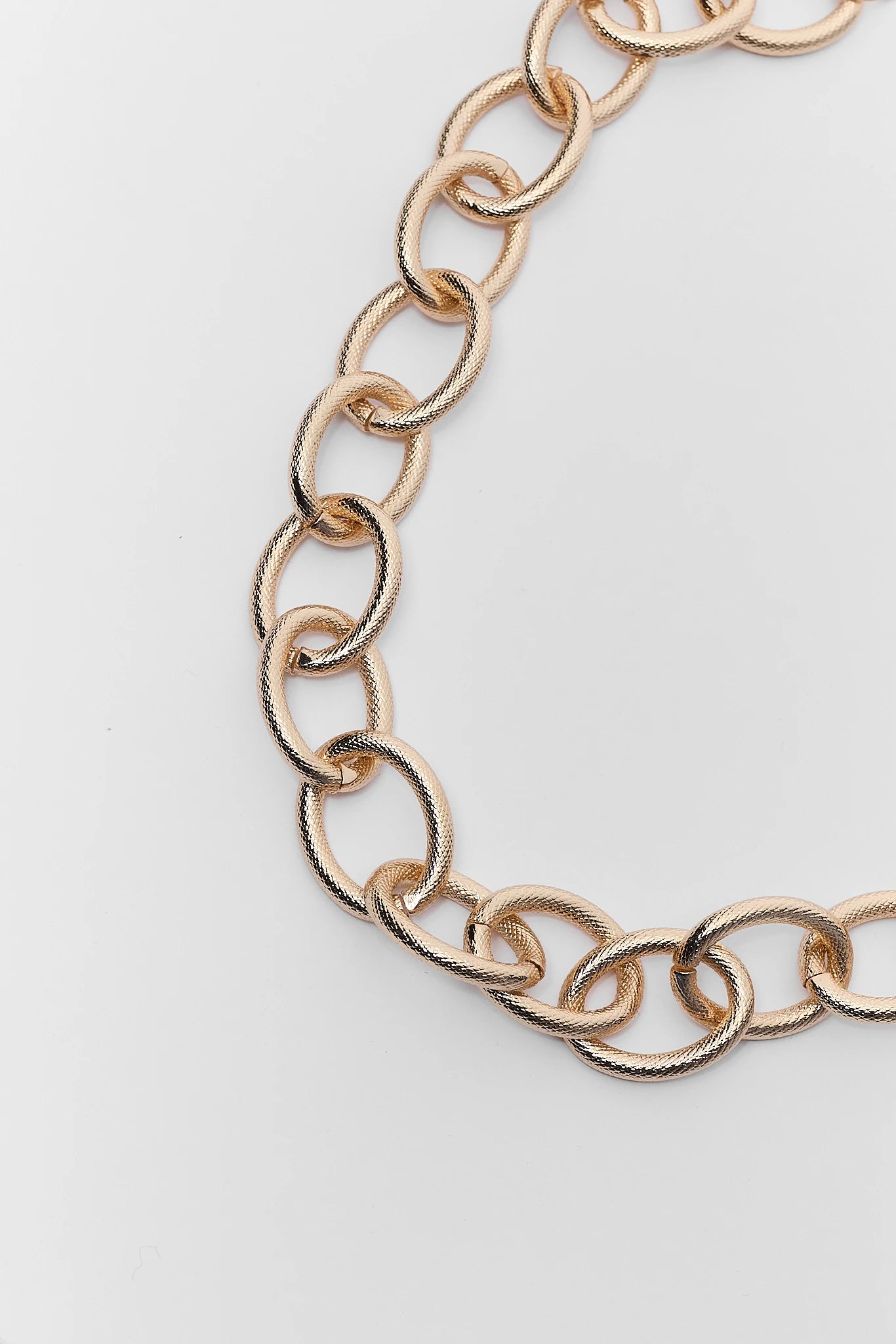 close up Gold chain necklace on a light gray background
