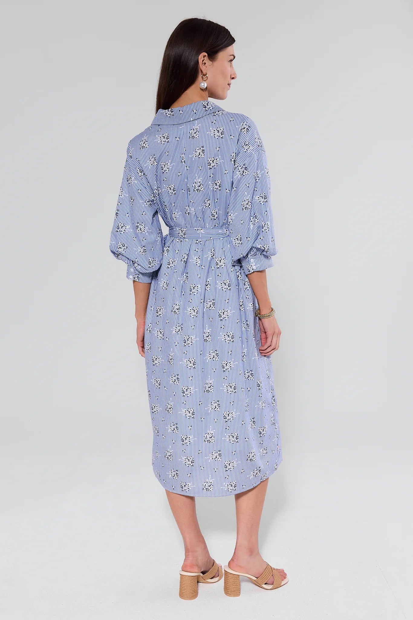 Woman wearing a blue floral dress on a light gray background