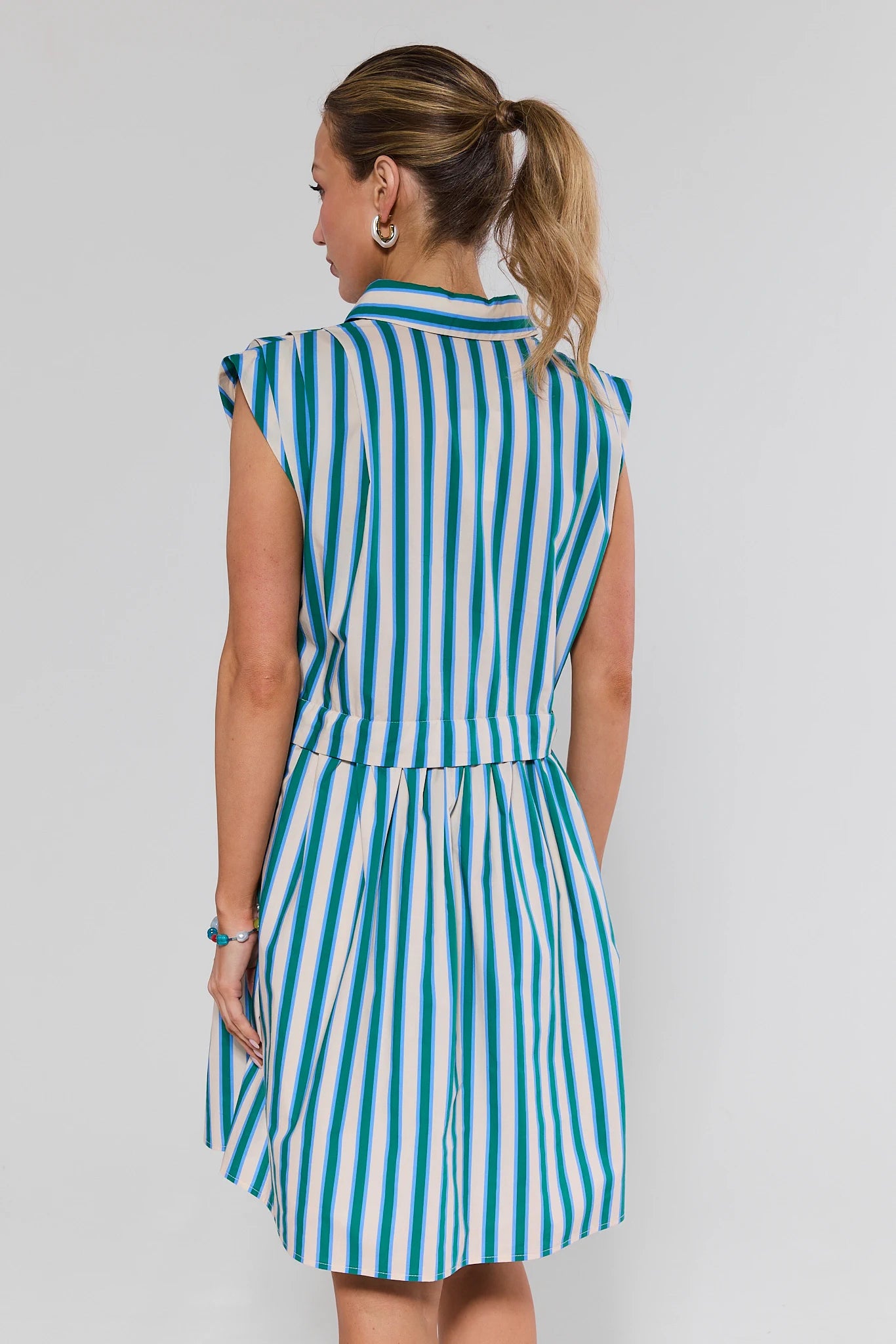Woman wearing a blue and white striped dress on a gray background