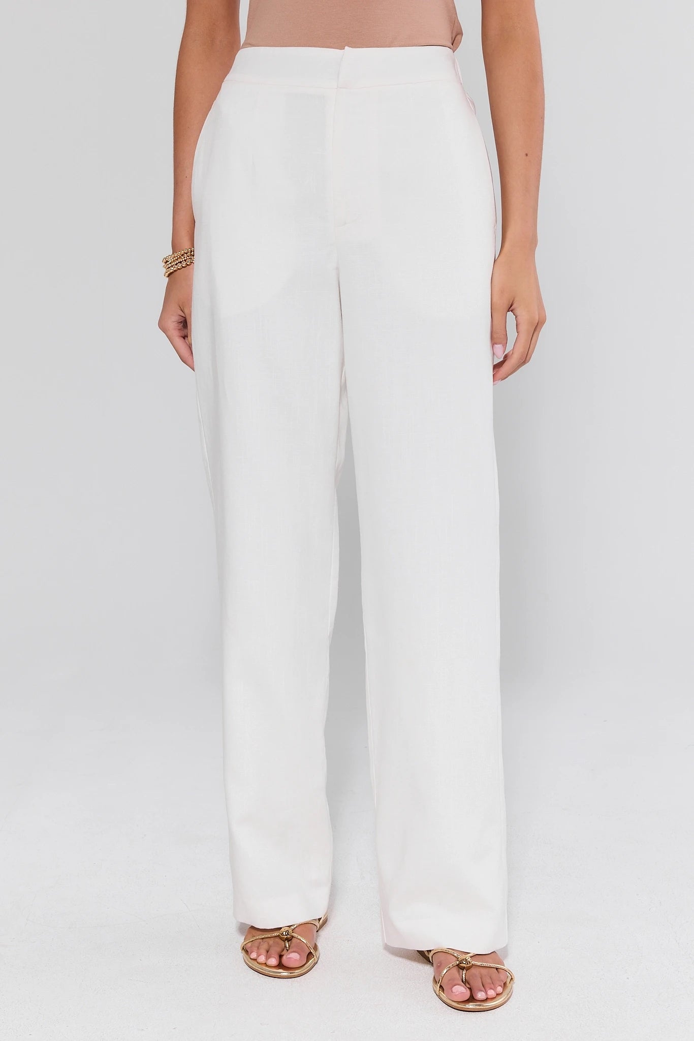 White pants worn by a person on a white background