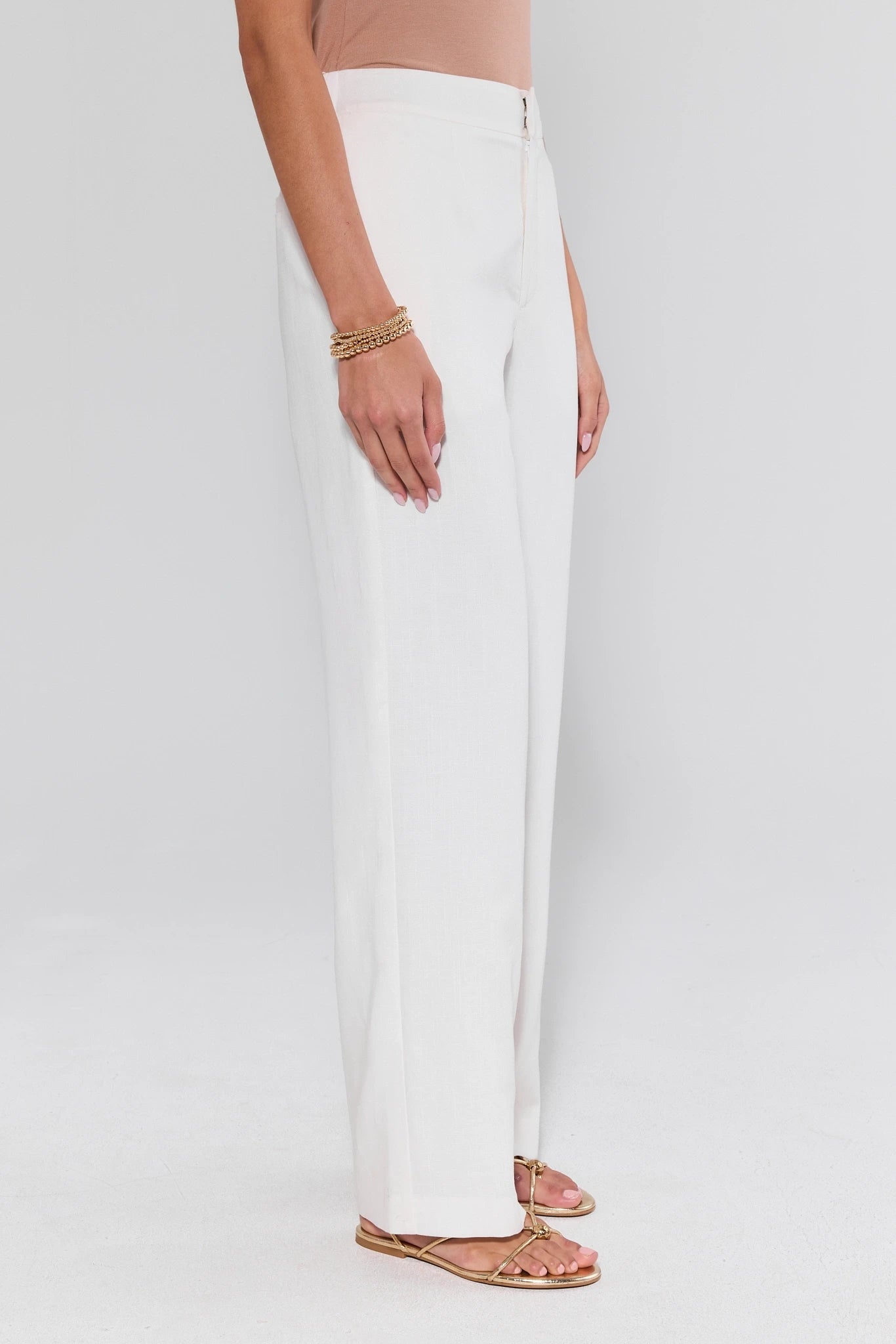 Person wearing white pants on a plain background