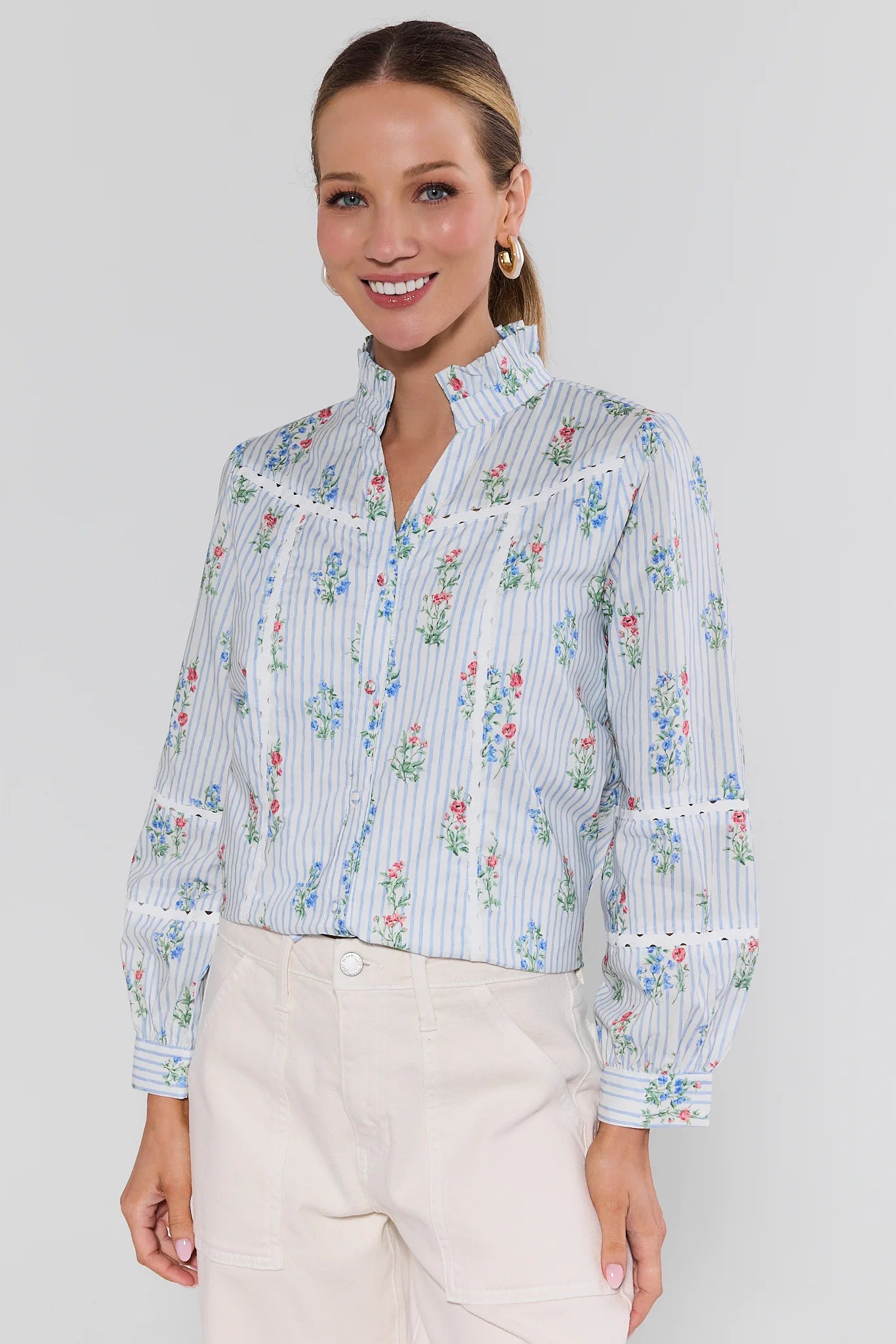 Woman wearing a floral striped blouse with a plain background