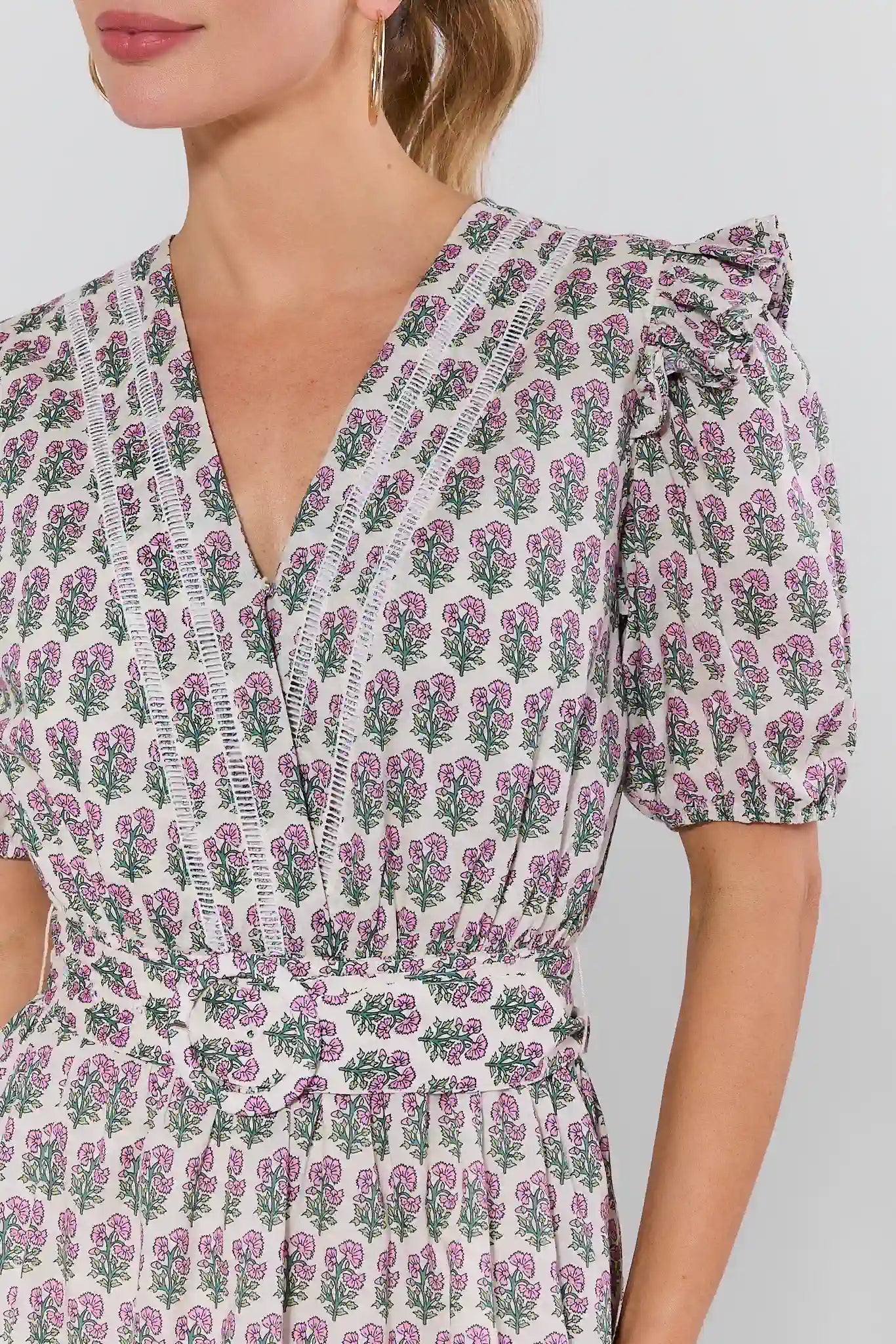 close up of Woman wearing a floral dress with a plain background