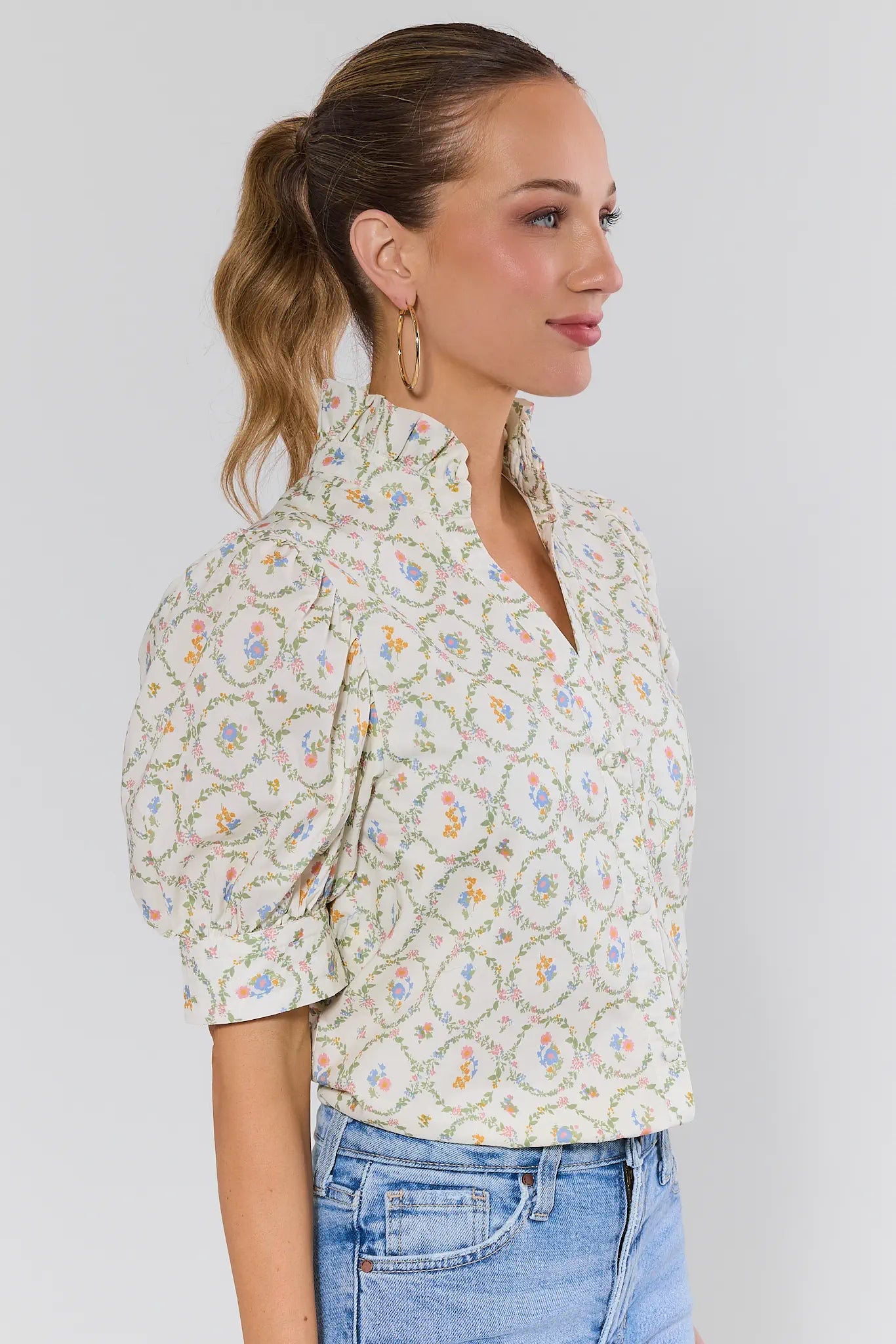 Woman wearing a floral blouse and jeans on a background