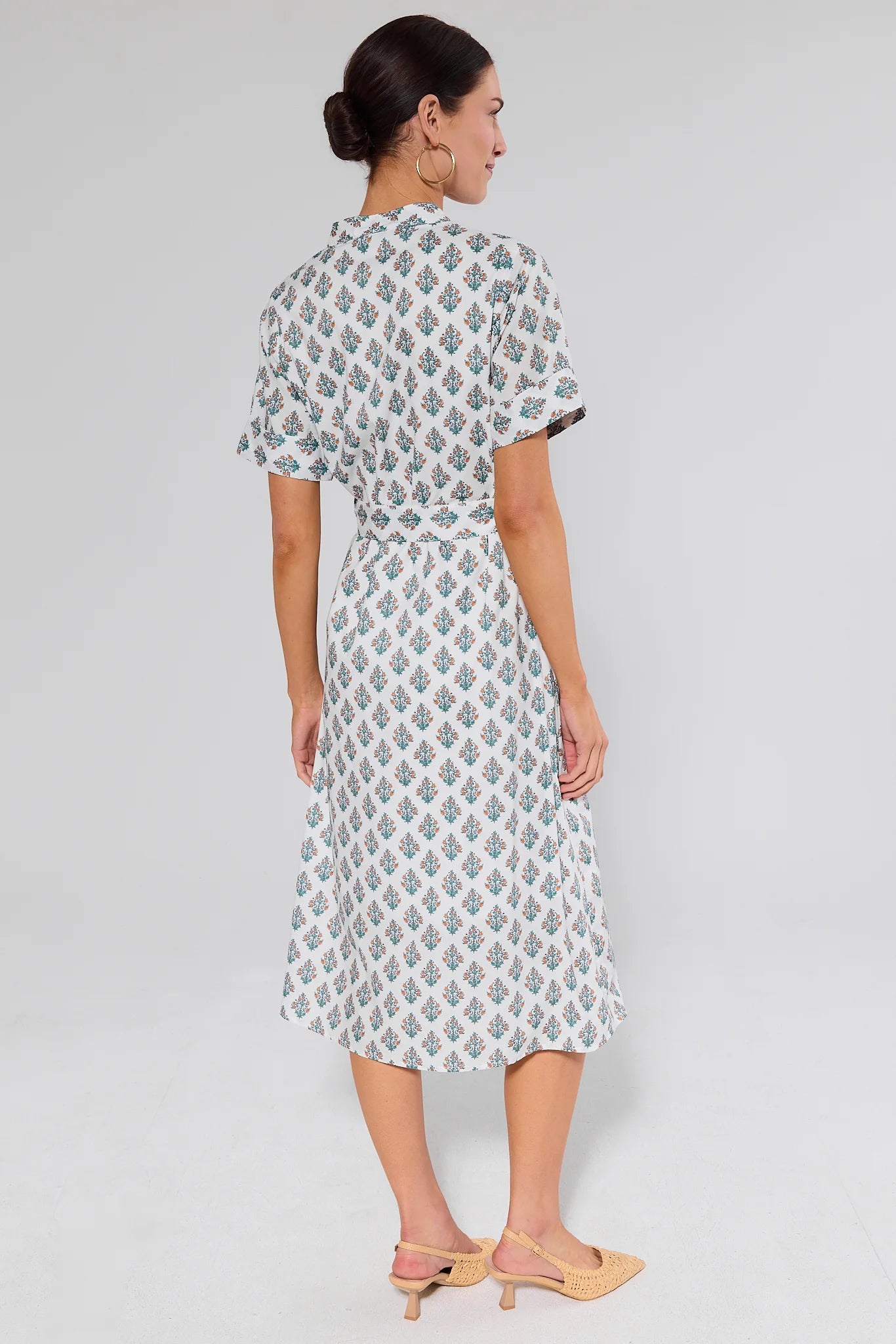 woman wearing white dress with floral block print on white background