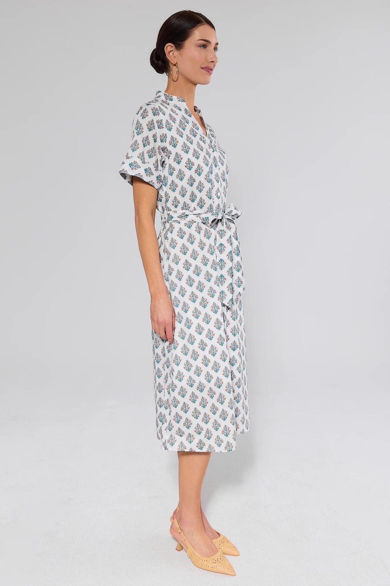 Woman wearing a patterned tina dress on a plain background