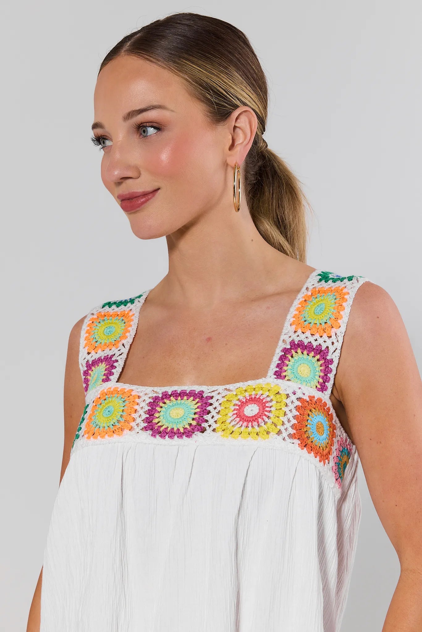close up Woman wearing a white dress with colorful floral patterns on a plain background