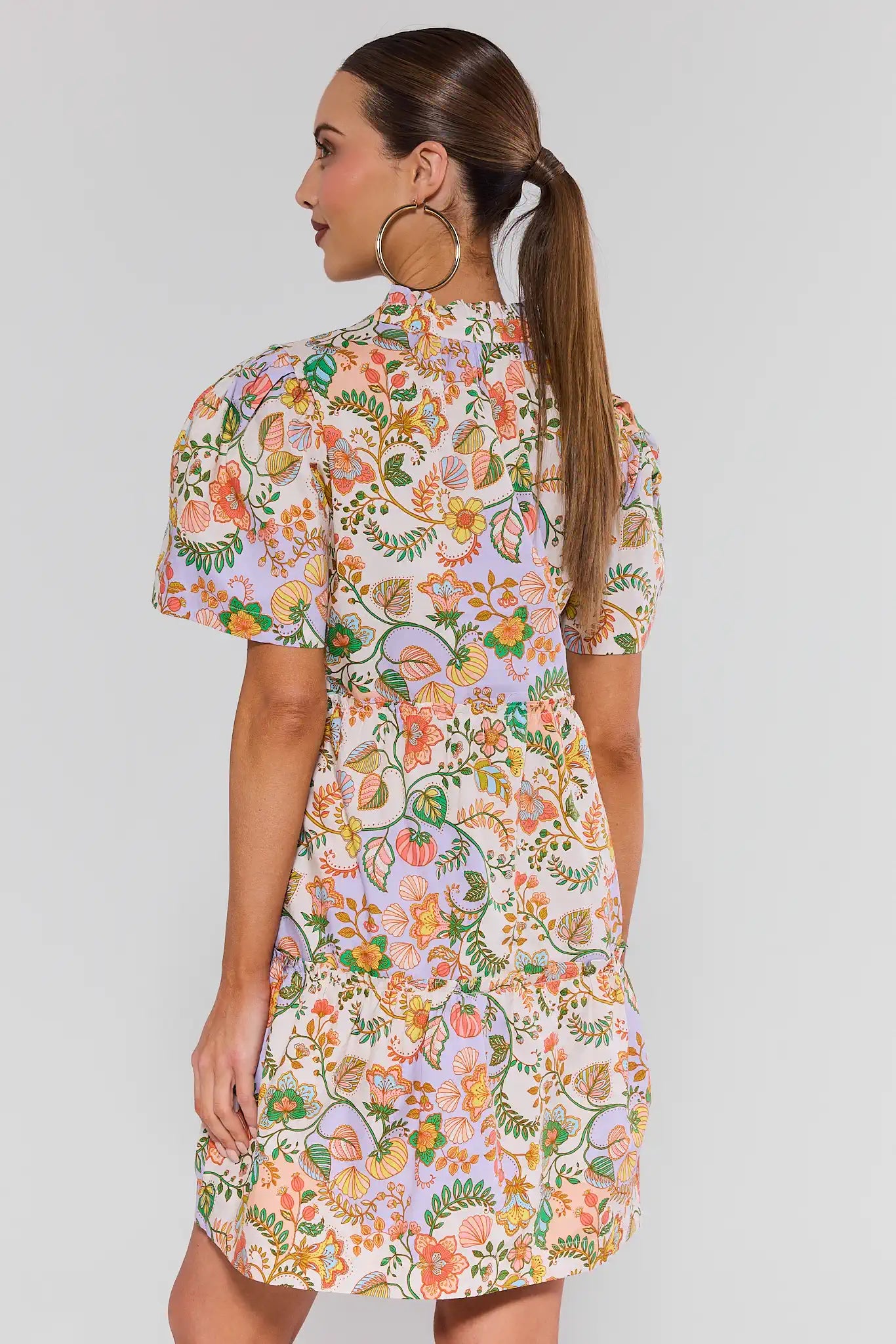 Woman wearing a floral dress on a plain background