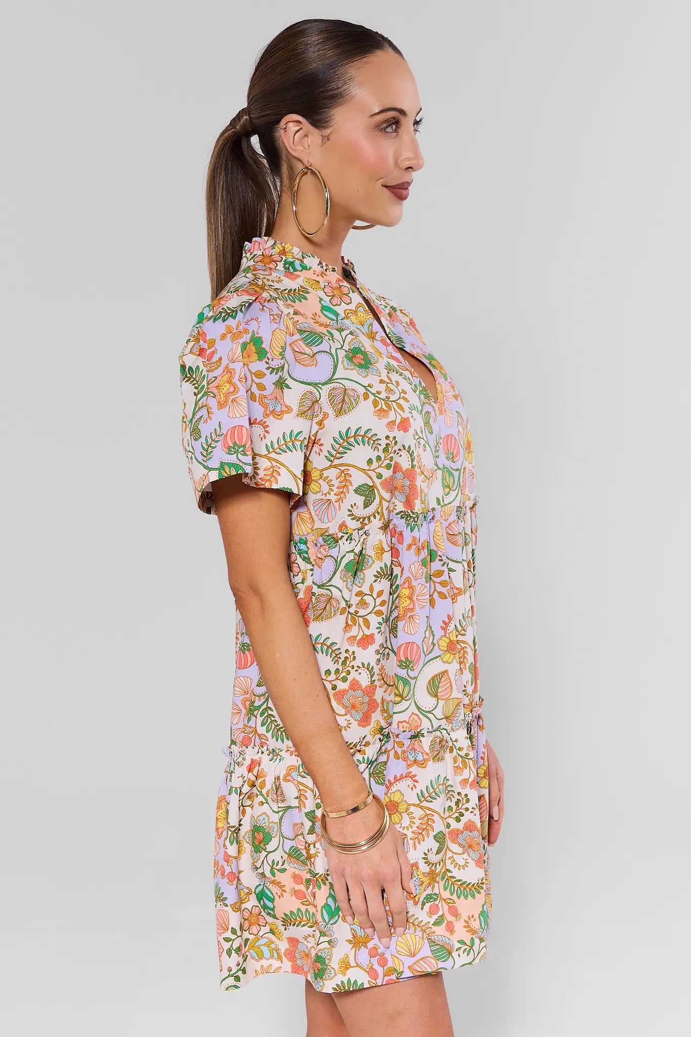 Woman wearing a floral dress against a plain background