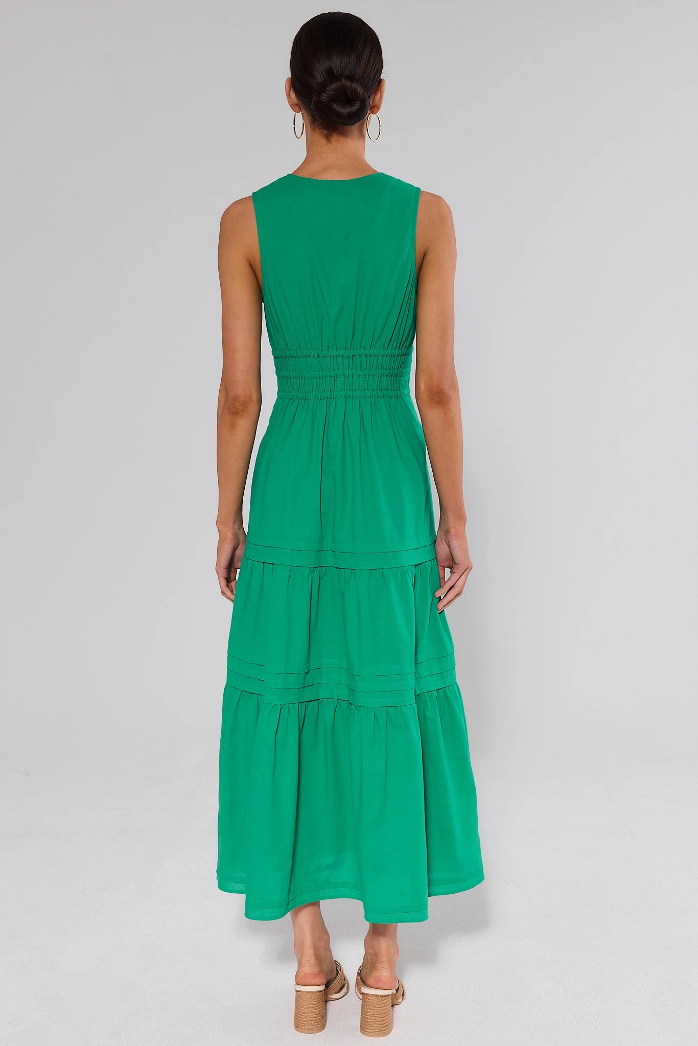standing Green dress with tiered skirt worn by a model on a plain background