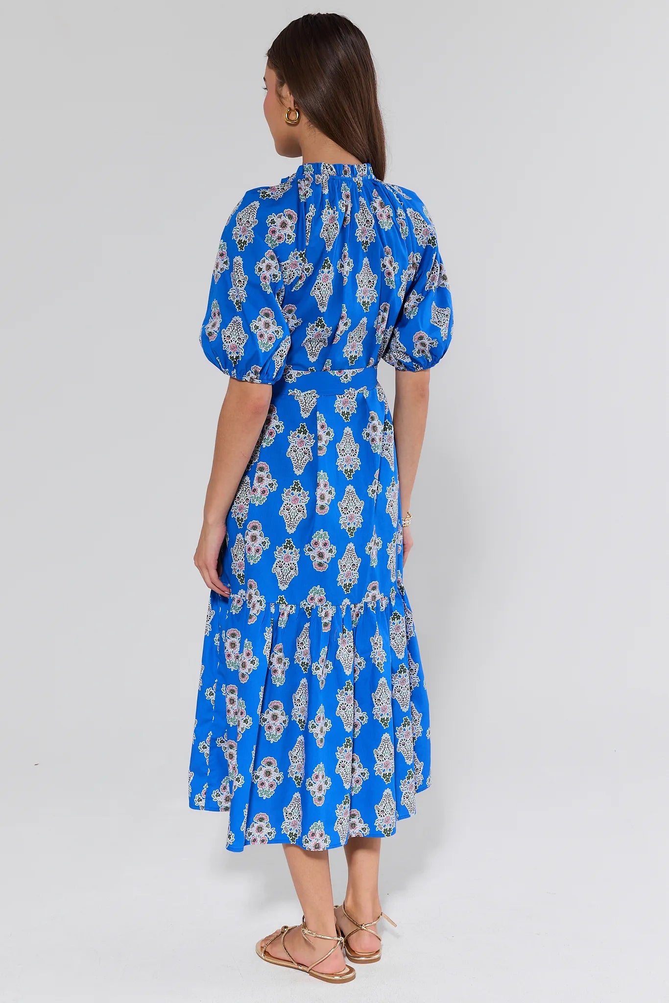 Woman wearing a blue floral dress on a white background