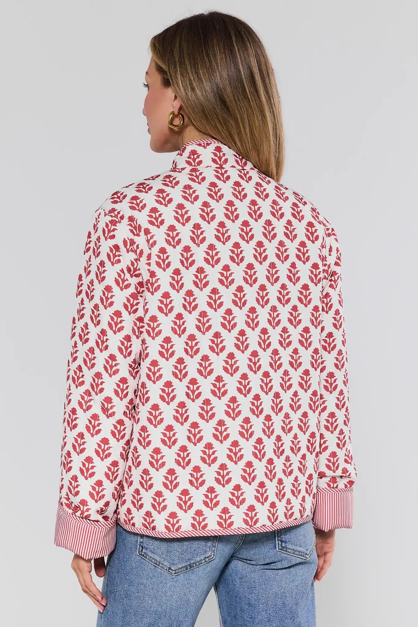 Woman wearing a red floral patterned shirt with a white background