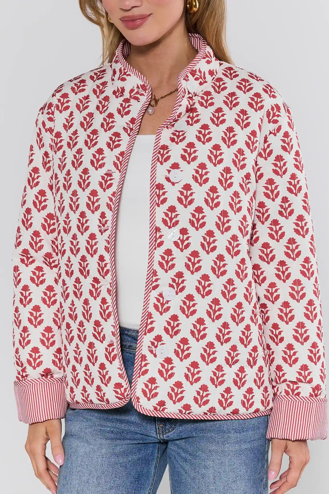 Person wearing a red floral patterned jacket on a plain background