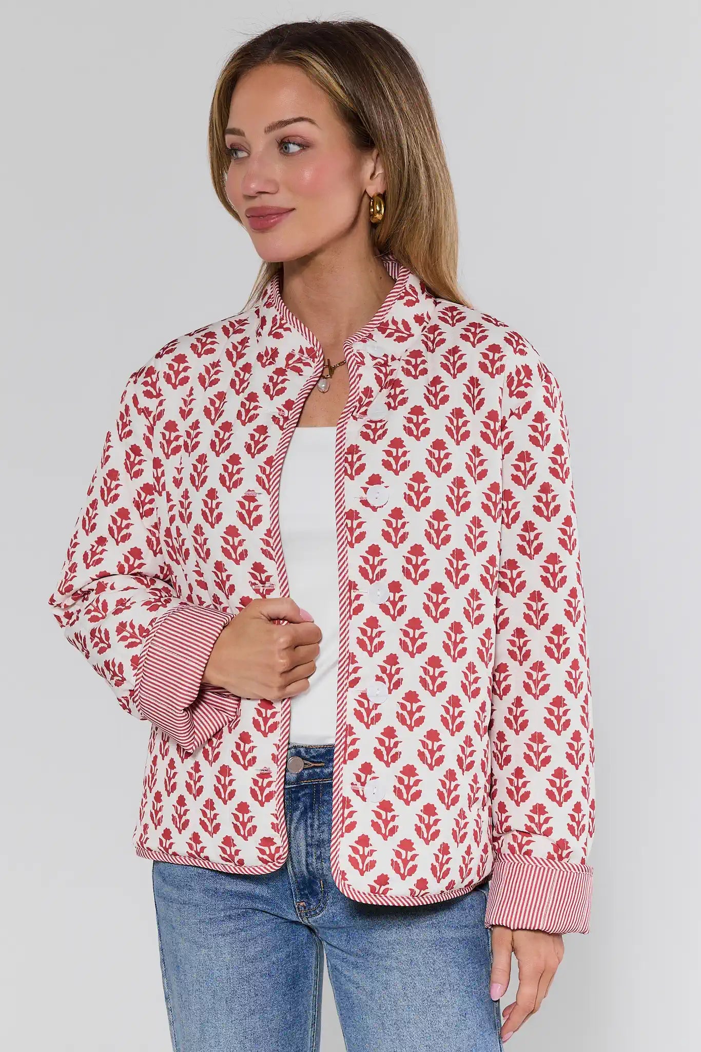 Woman wearing a red floral patterned jacket on a plain background