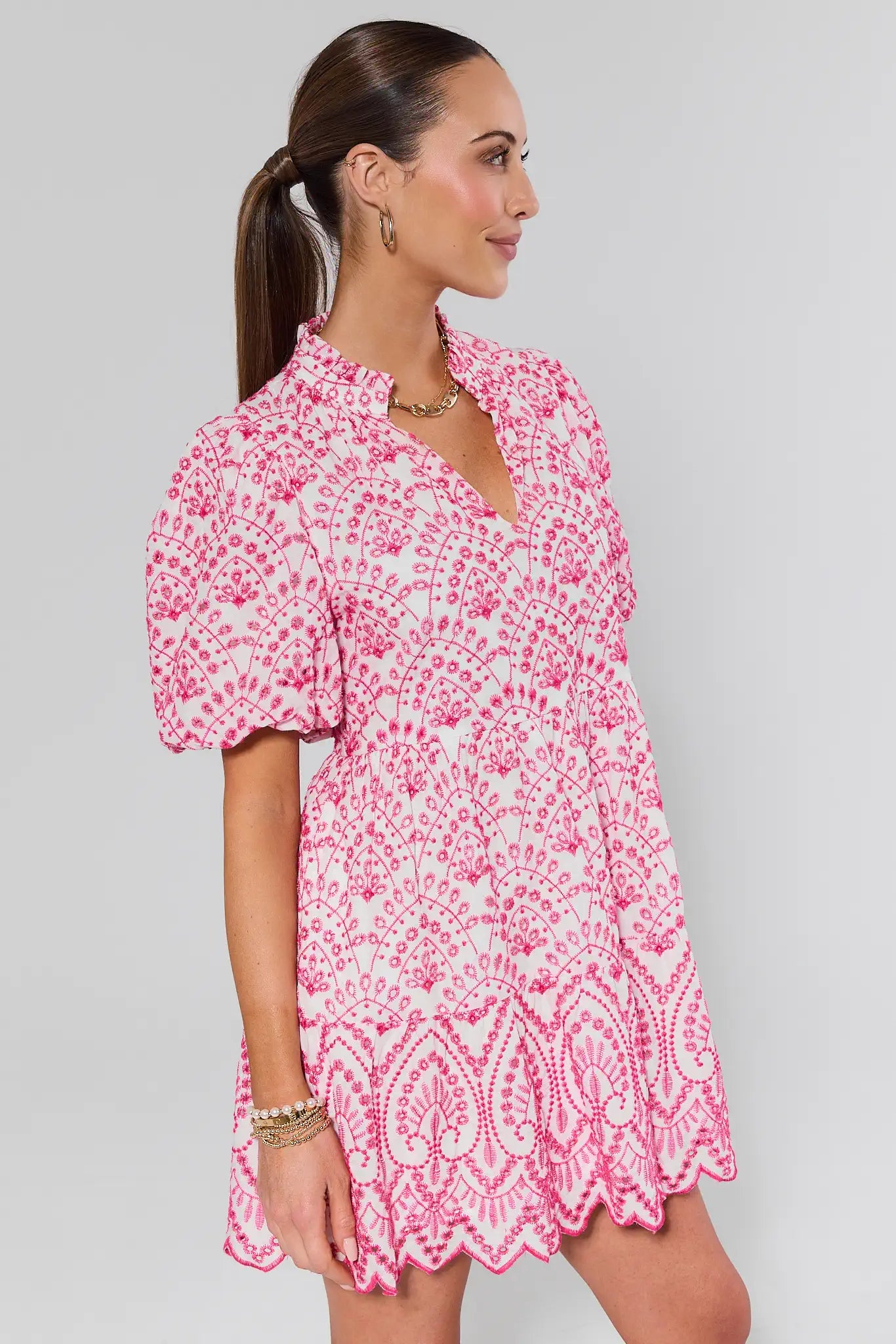 Woman wearing a pink floral dress on a gray background