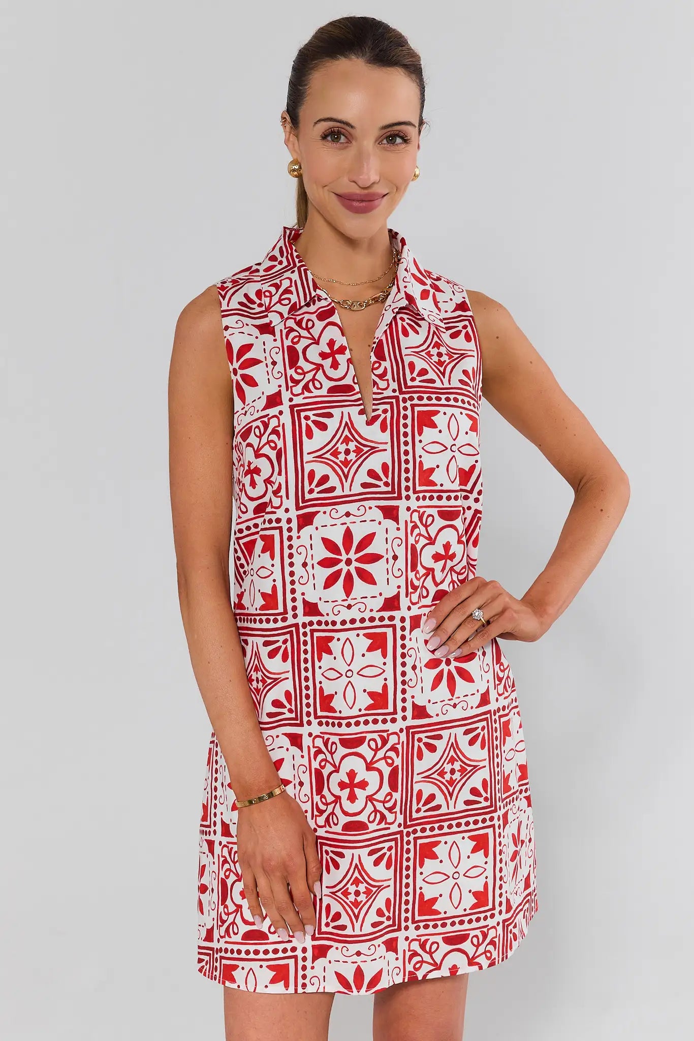 Woman wearing a red and white patterned dress against a plain background