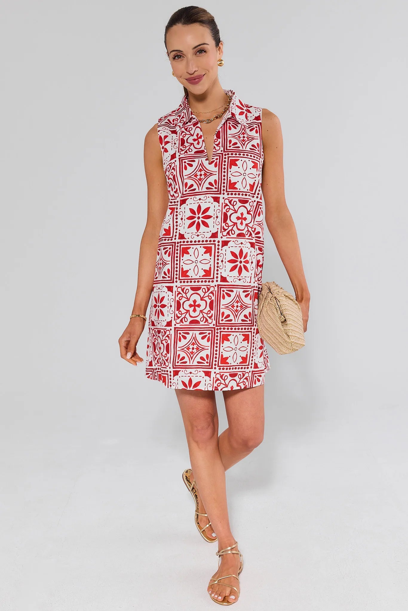 Woman wearing a ellen red and white patterned dress on a plain background