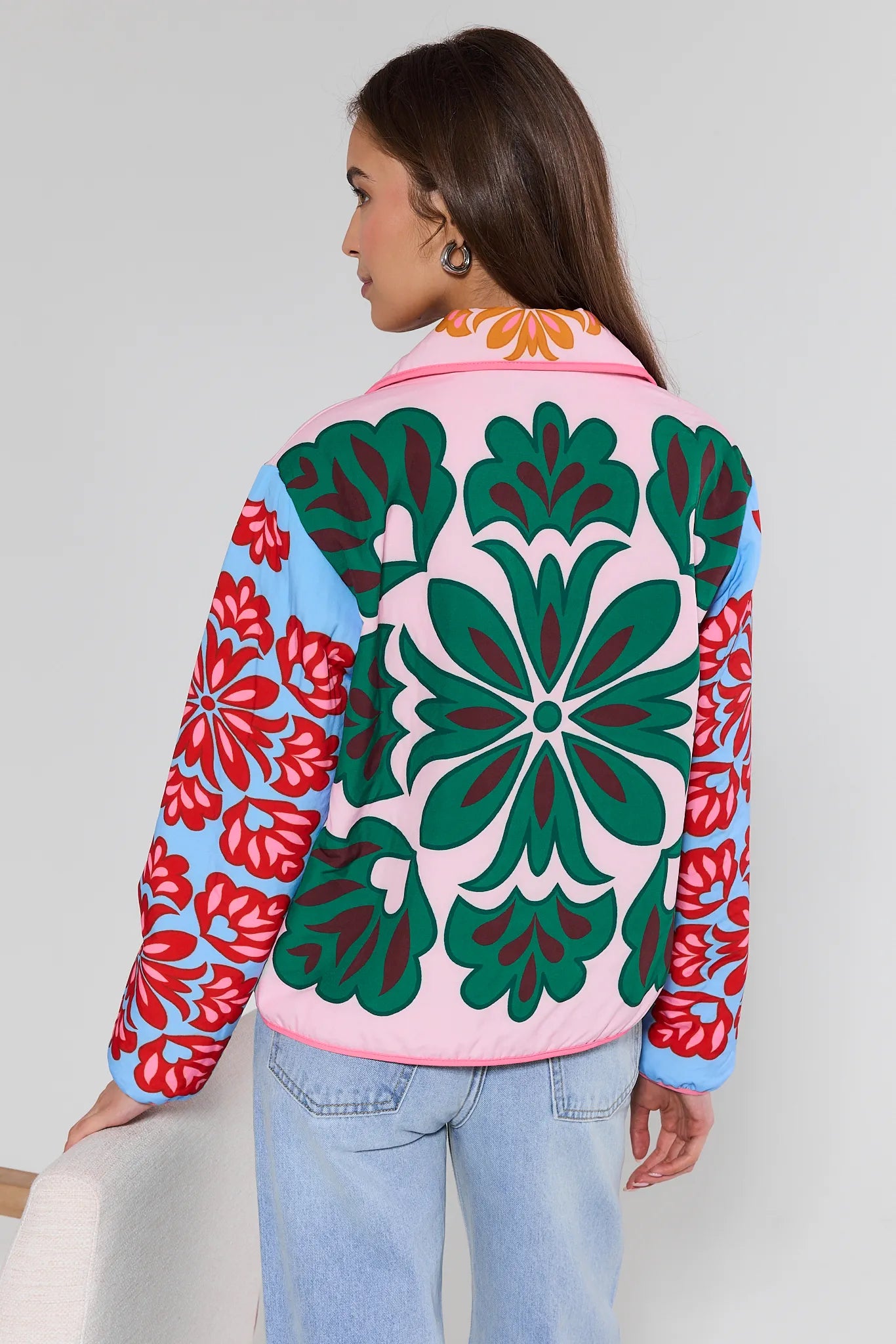 woman wearing green printed jacket with jeans on white background