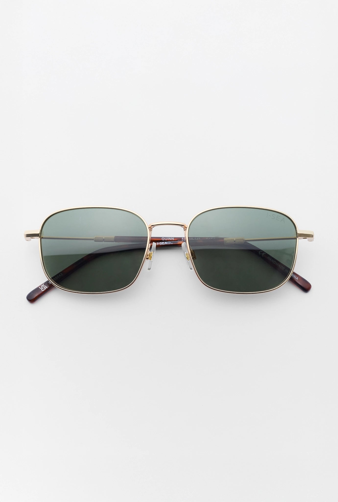 Sunglasses with gold frame and dark lenses on a white background