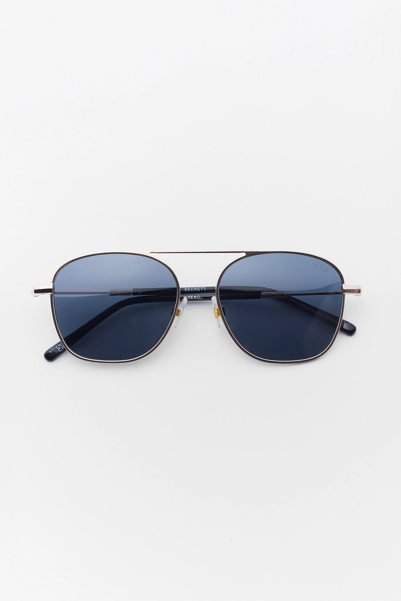 Sunglasses with dark lenses and gold frame on a white background