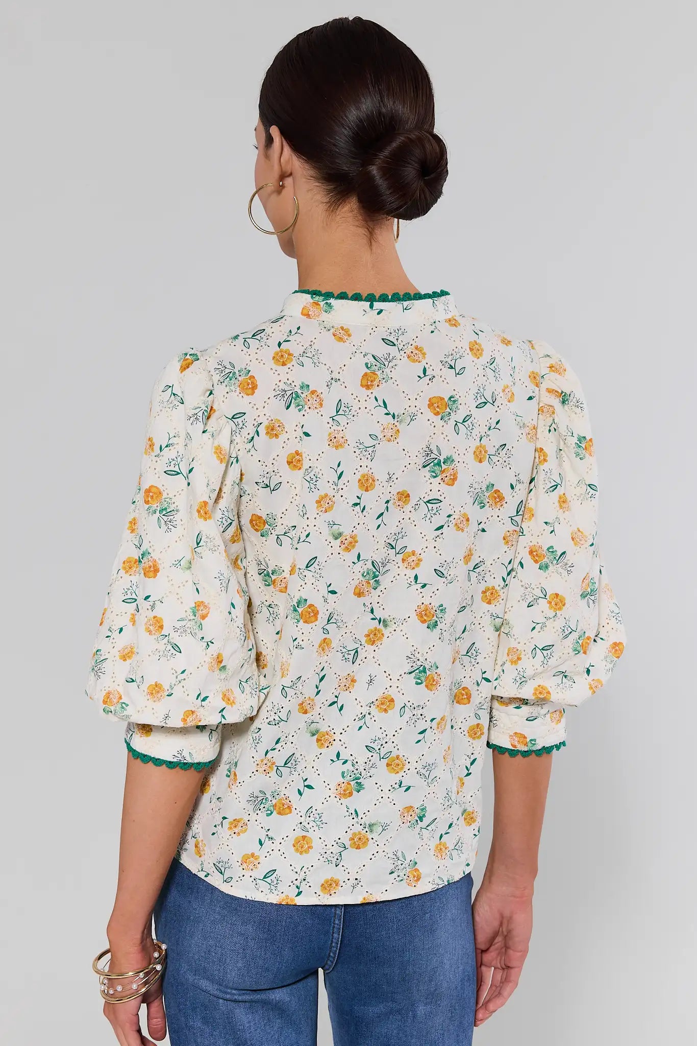 Woman wearing a floral blouse with a plain background