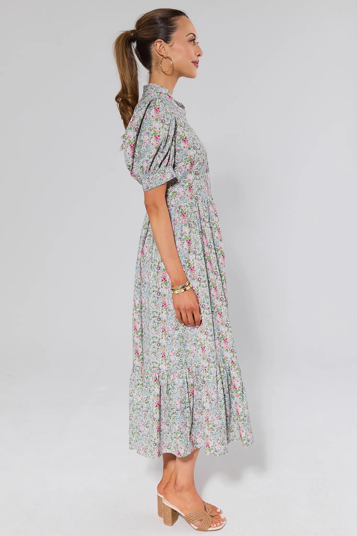 side shot Woman wearing a floral dress on a plain background
