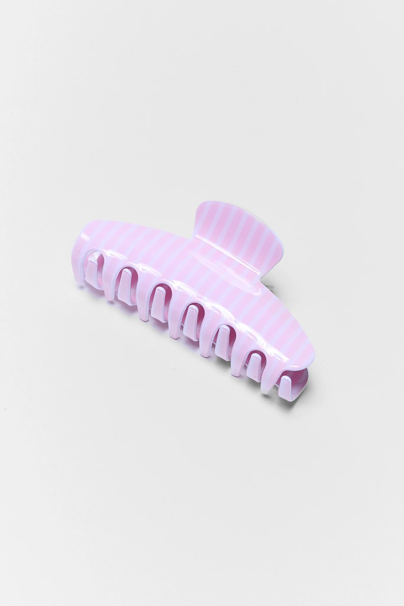 Pink hair clip on a light gray background