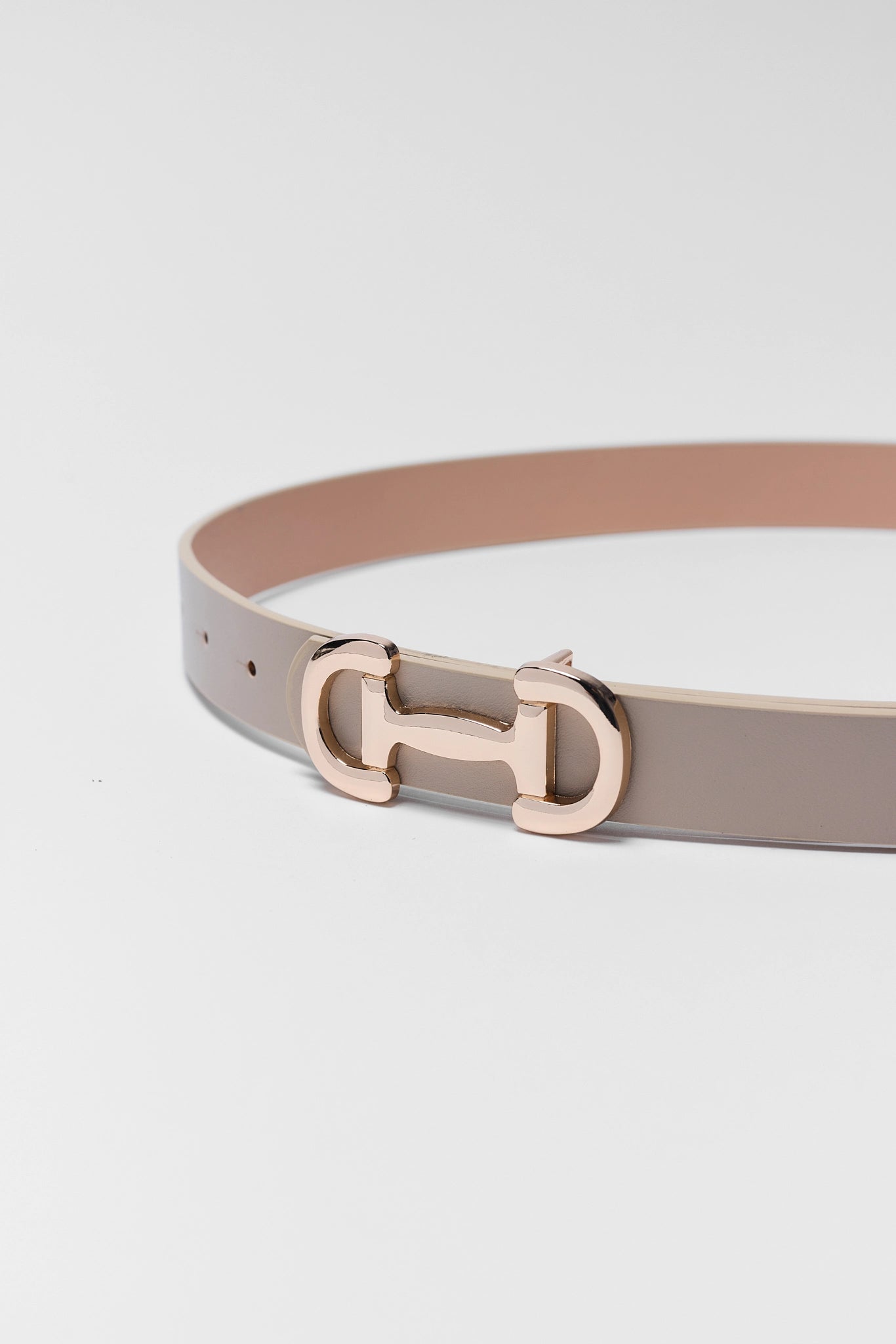 Belt with a gold buckle on a light gray background