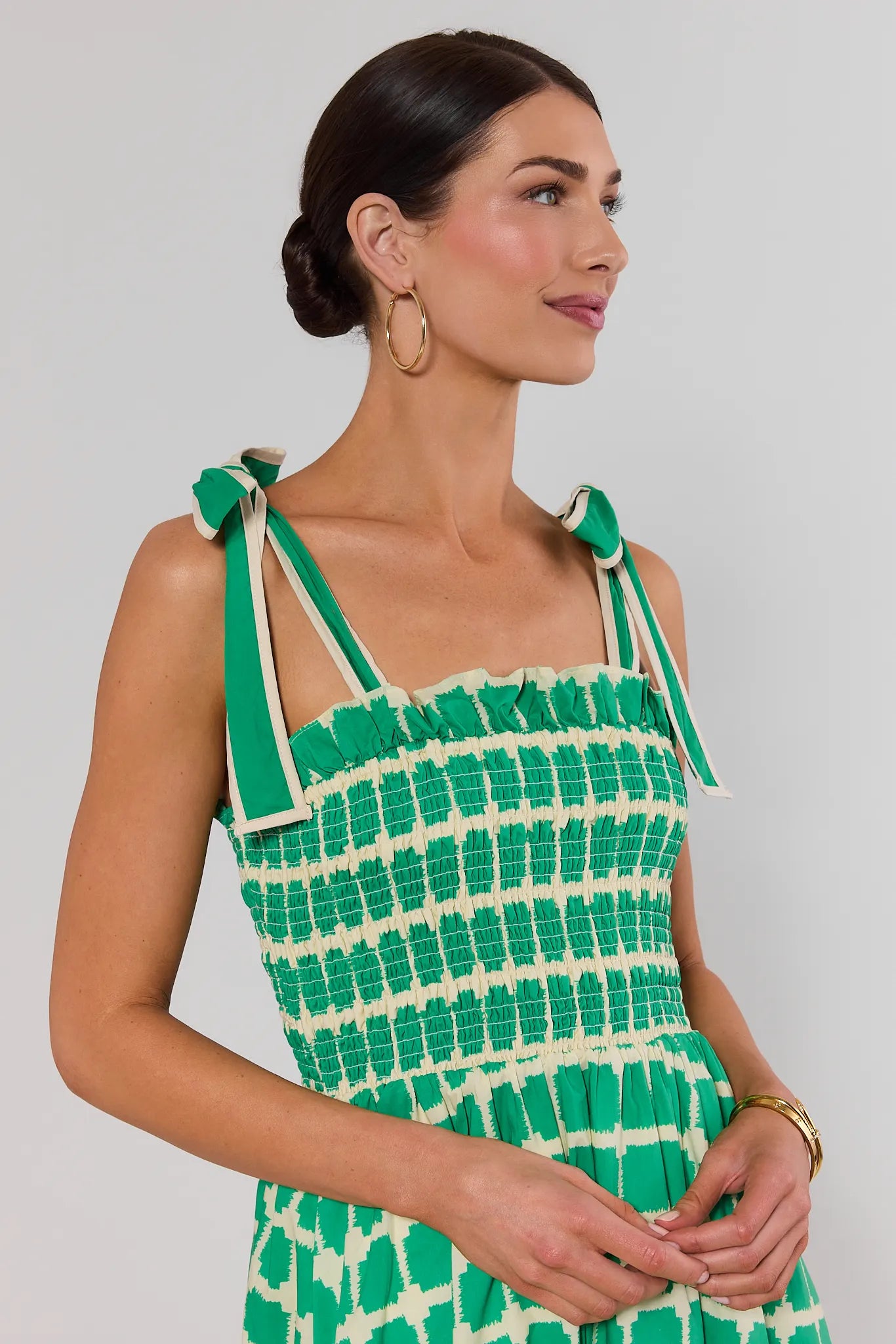 close up woman wearing green talia dress on white background