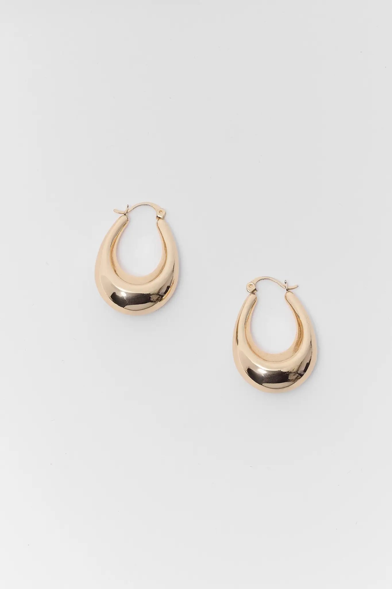 Gold hoop earrings on a light gray background
