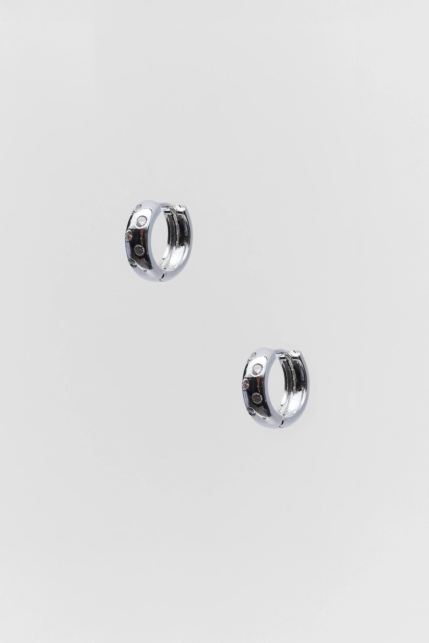 Pair of silver hoop earrings on a light gray background