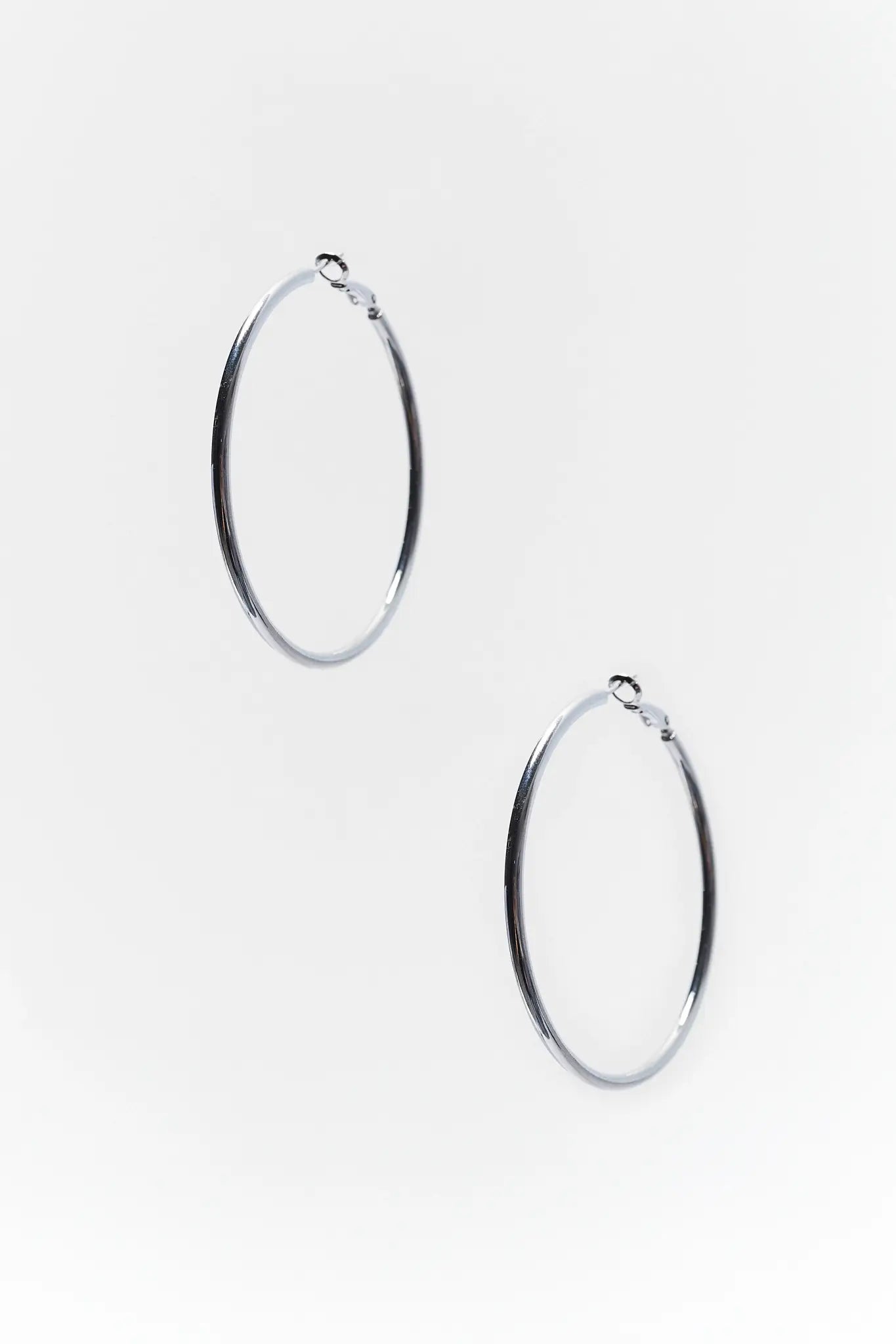 Pair of silver hoop earrings on a white background