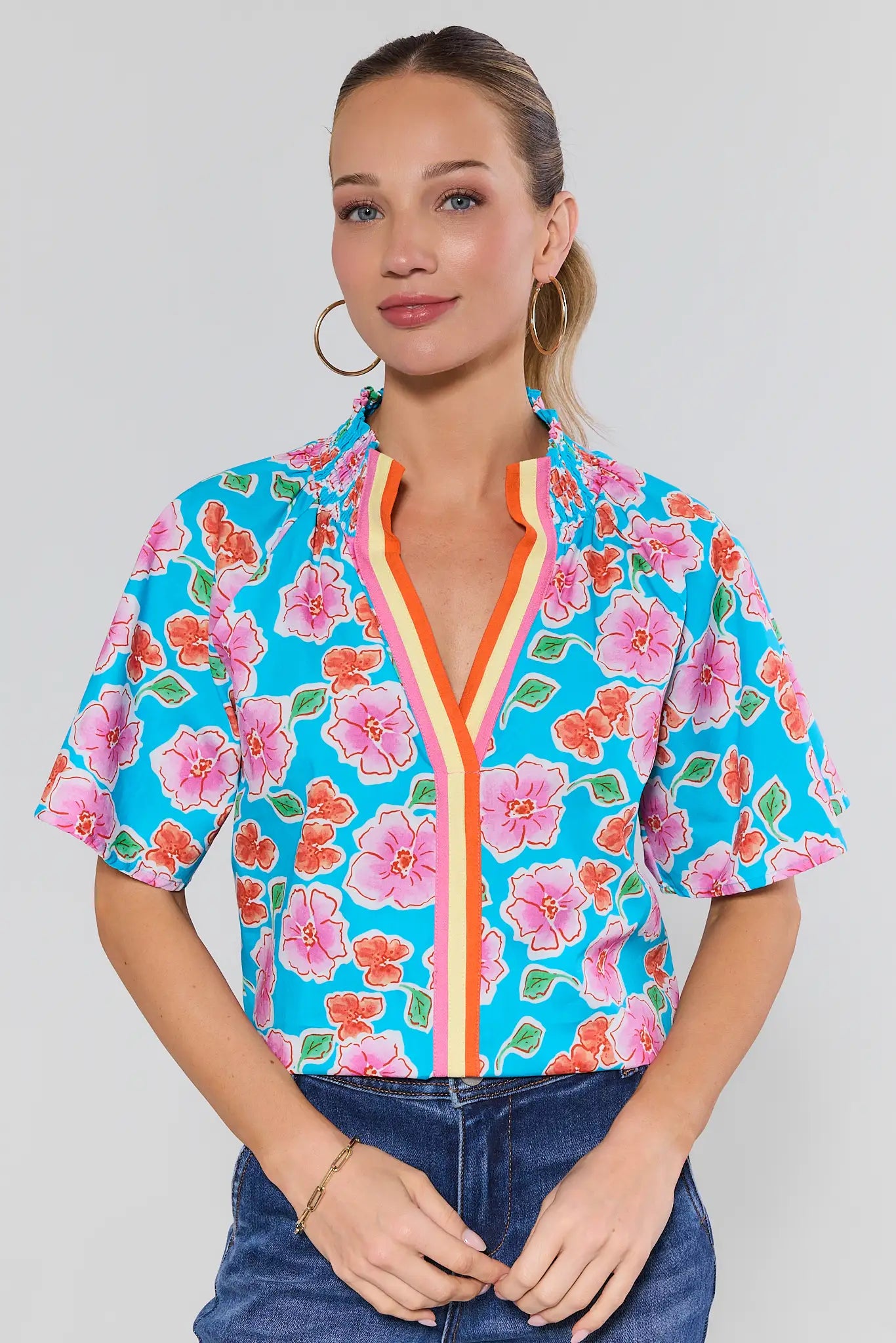 Woman wearing a colorful floral blouse with a white background