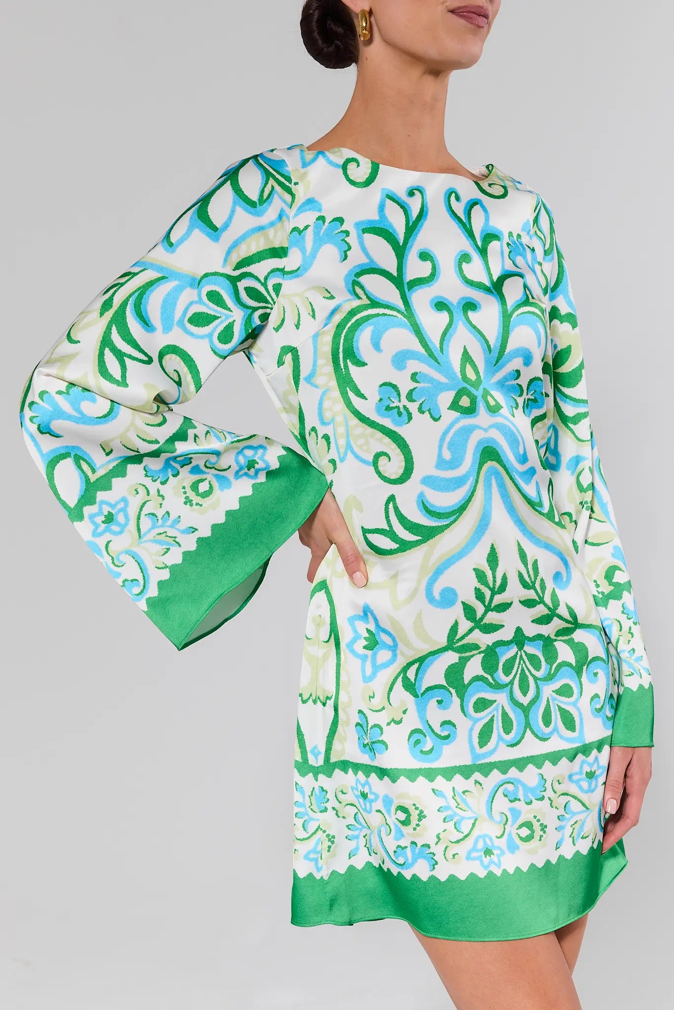 close up Woman wearing a green and blue patterned dress on a gray background