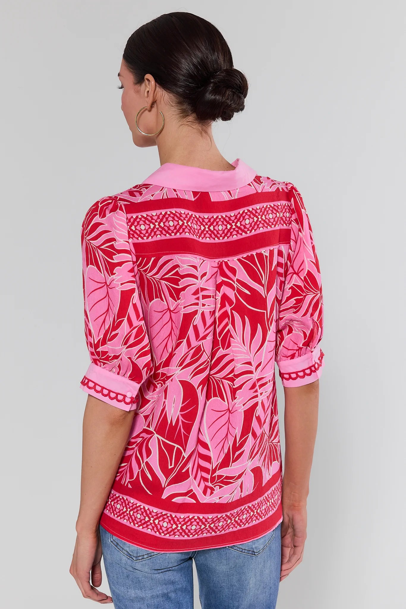 Woman wearing a pink patterned top with a white background