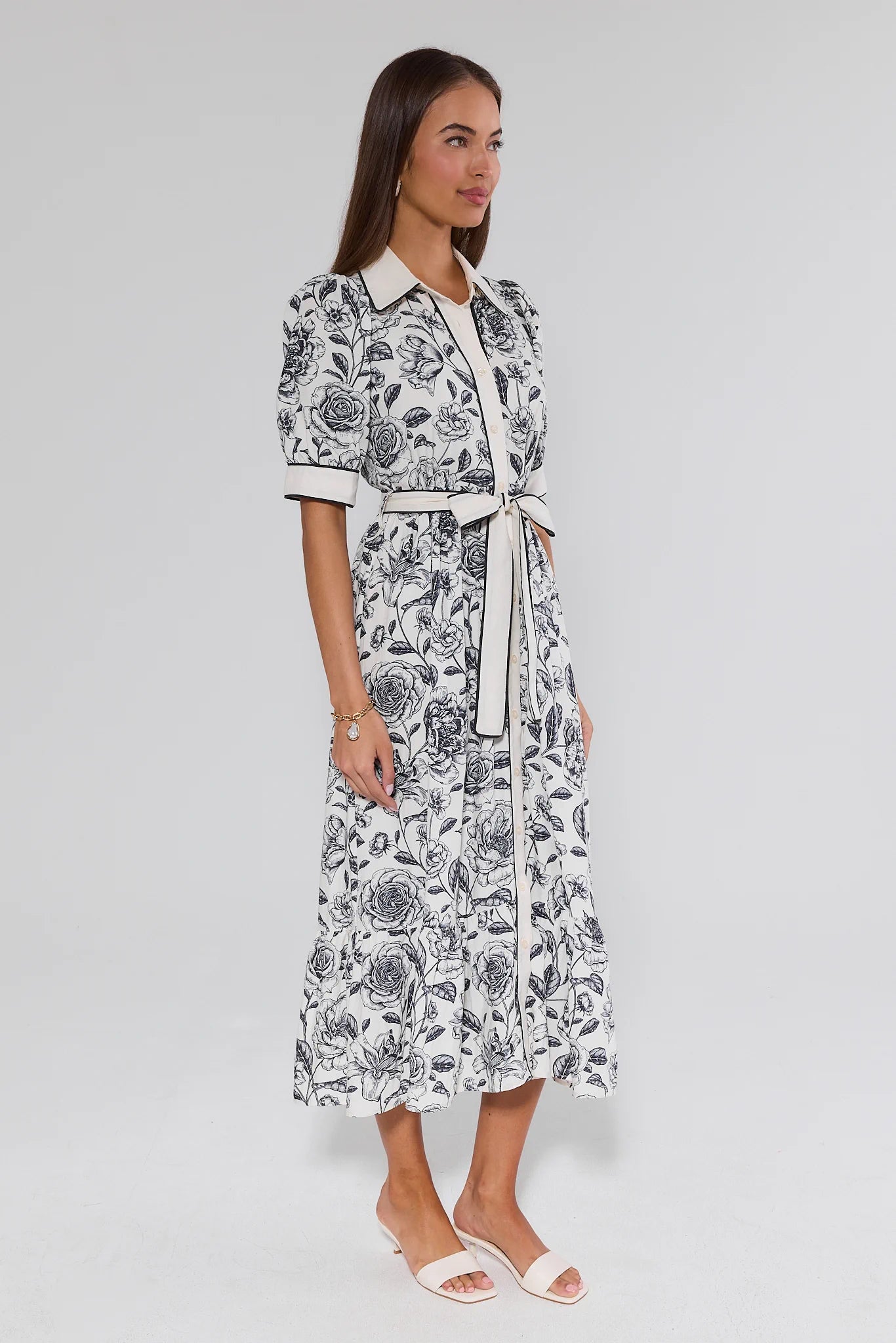 Woman wearing a black and white floral dress on a gray background