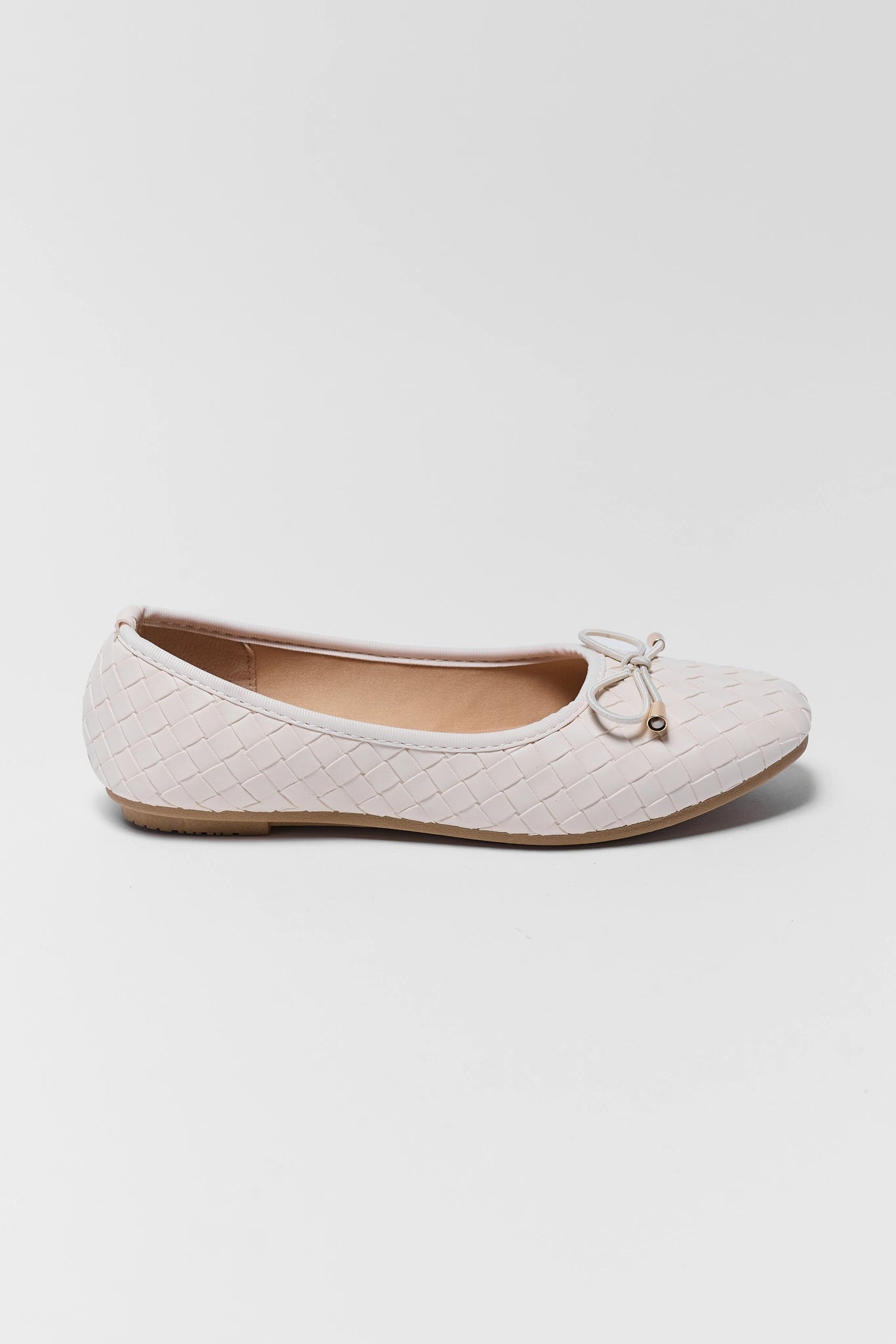 White quilted ballet flat shoe on a light gray background